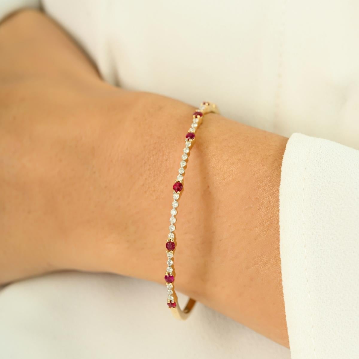Gracieusement réalisé en or jaune 14 carats, cet élégant bracelet présente une combinaison brillante de 0,55 carats de pierres rouges vives et de 0,37 carats de diamants étincelants. L'alternance de pierres semblables à des rubis et de diamants