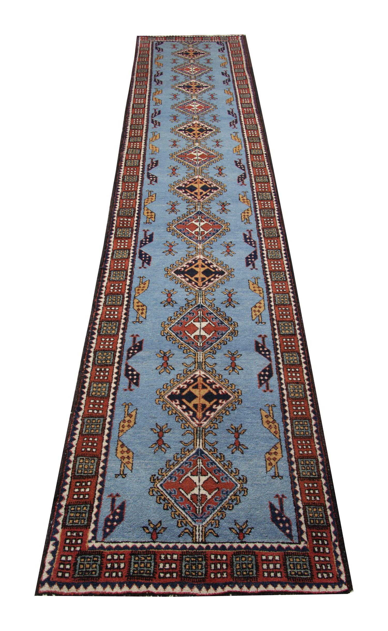 This beautiful blue vintage rug was handwoven in 1950. The Medallions that run through the centre have intricate details woven in colors that contrast against the blue field, including beige, red, ivory and orange. This central design is then