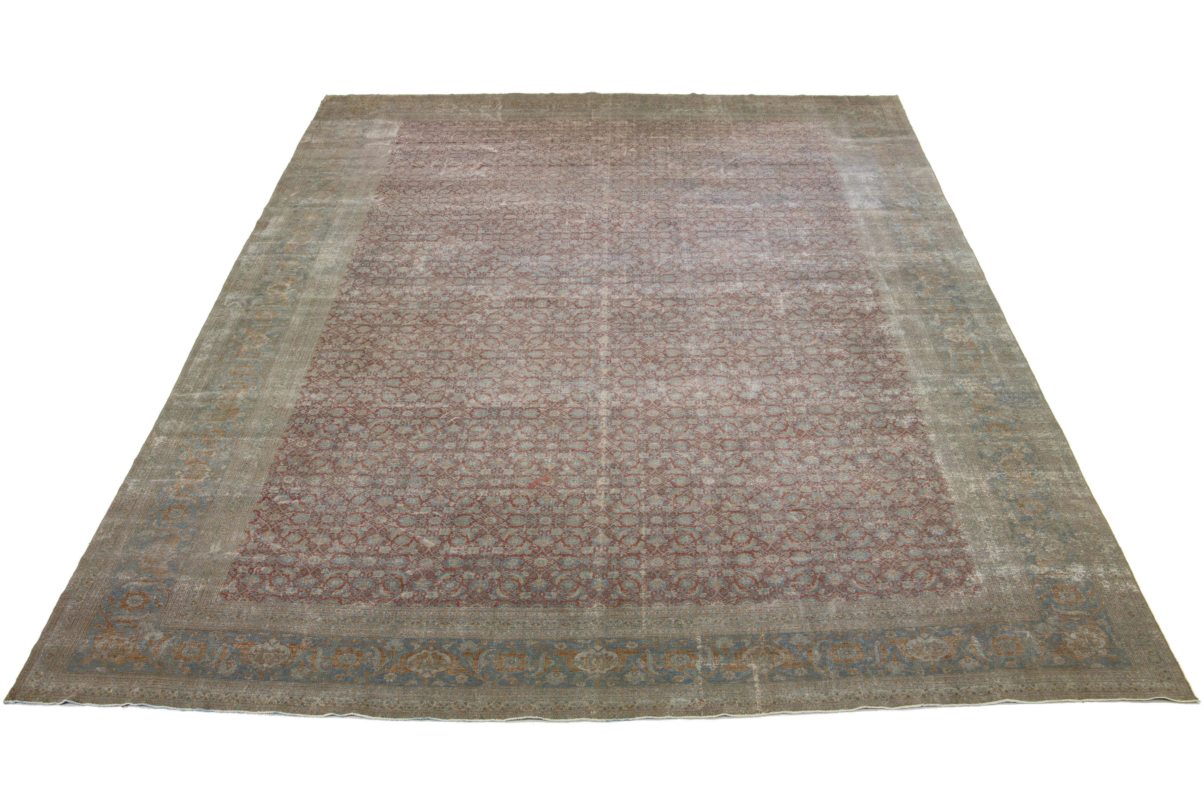 This Persian Tabriz wool rug features a classic all-over floral pattern on a rust background with shades of orange and light blue. The rug is beautifully handcrafted.

This rug measures  14'2