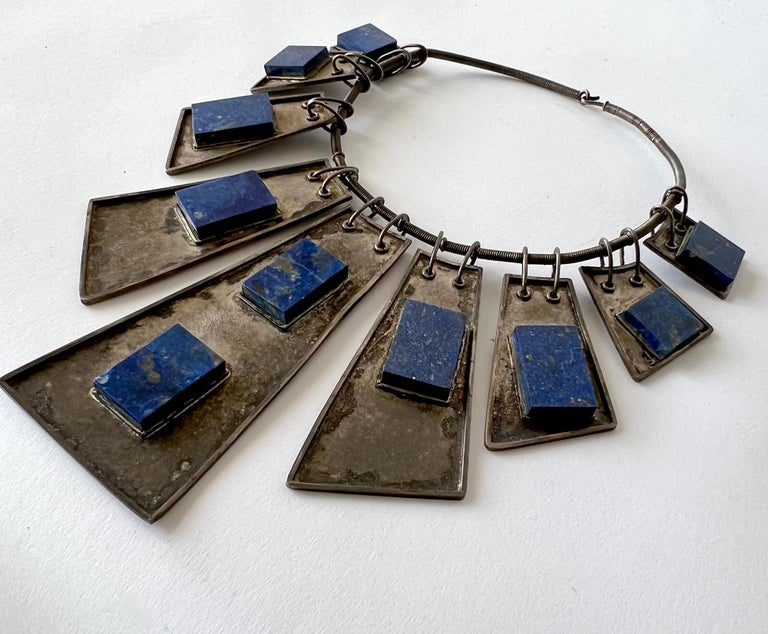 Handmade large scale necklace made up of nine trapezoid shaped silver plaques with thick rectangular and square cut lapis lazuli stones, circa 1970s or 1980s.  Choker has 17