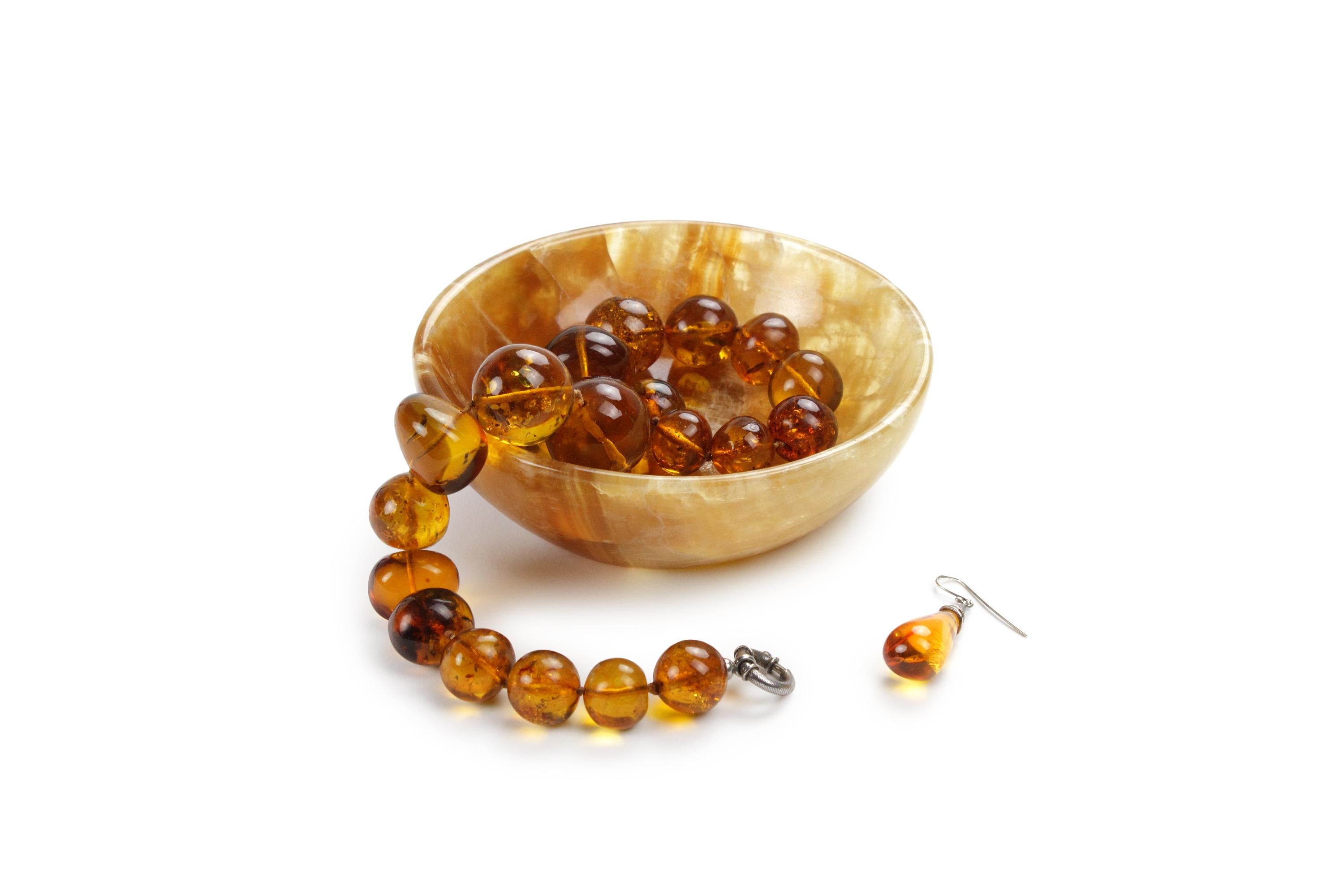 Hand carved small bowl from Amber onyx. Multiple use as serving bowl, finger food, to hold jewelry or bathroom accessory. The polished finishing underlines the transparency of the onyx making this a very precious object. 

Dimensions: D 15, H 5 cm.