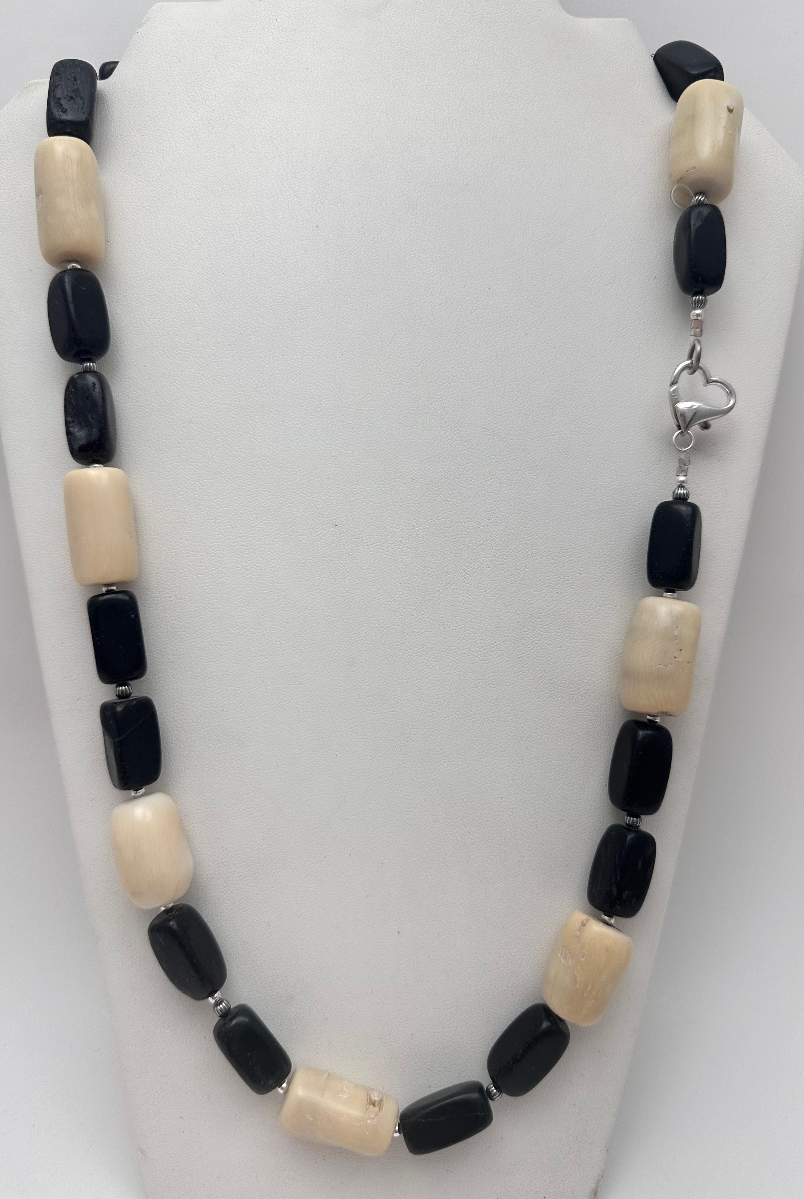 This beautiful handmade necklace is crafted from high-quality sterling silver (.925) and features a gorgeous beige barrel coral beads. The necklace is adorned with black beaded accents and has a heart shape lobster clasp. The necklace measures 28
