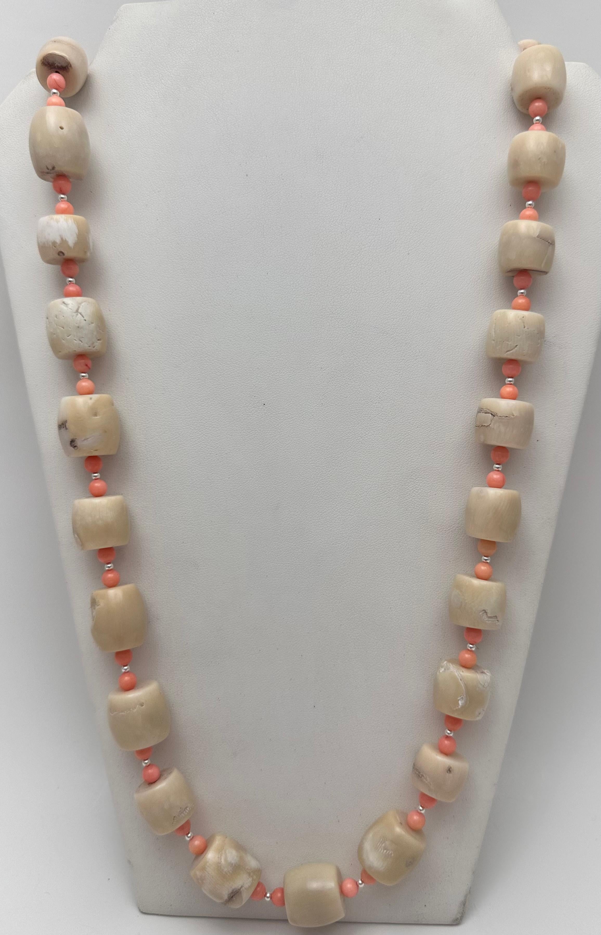 Diese atemberaubende handgefertigte 36-Zoll-Halskette besteht aus wunderschönen runden Korallenperlen in einem schönen Lachston, die mit beigen Tonnenperlen akzentuiert sind. Die Halskette ist aus hochwertigem 925er Sterlingsilber gefertigt und