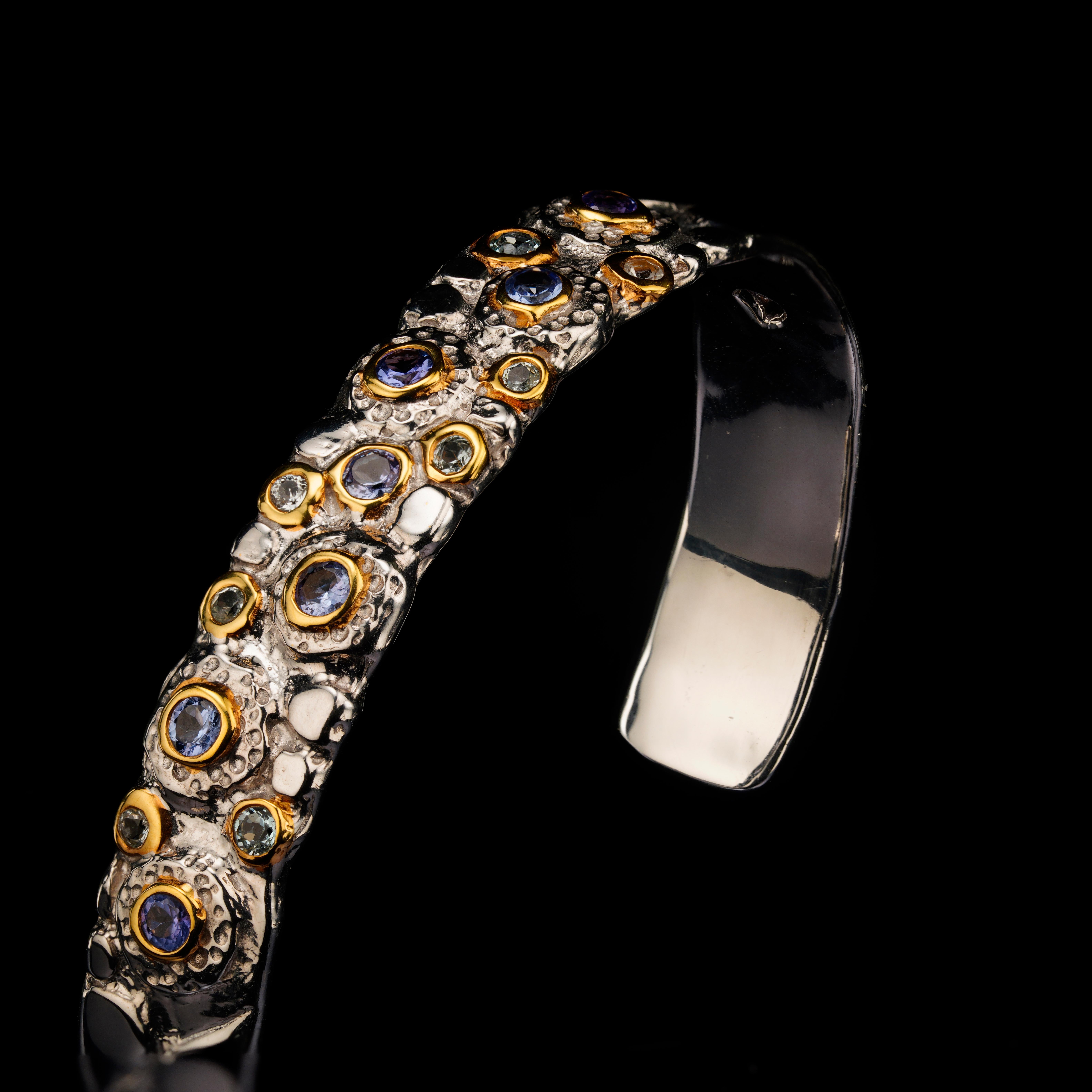 Questo squisito braccialetto fatto a mano in argento sterling con più pietre preziose e accenti in oro è una celebrazione del colore, dell'artigianato e dell'individualità. Meticolosamente forgiato in argento massiccio 925, presenta una miscela