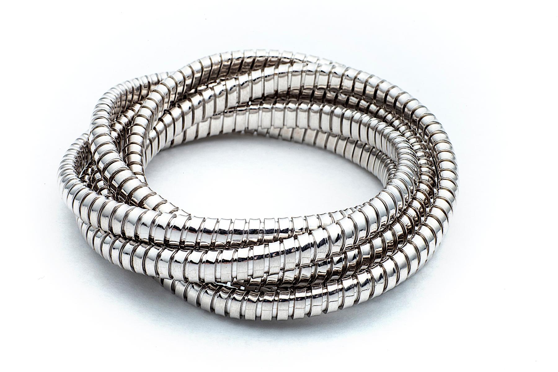 With a modernist mood, this intertwined six strand bangle bracelet represents the positive synergy between industrially engineered objects and their handmade jewelry version crafted today.  Inspired by the flexible metal piping from luxury sports