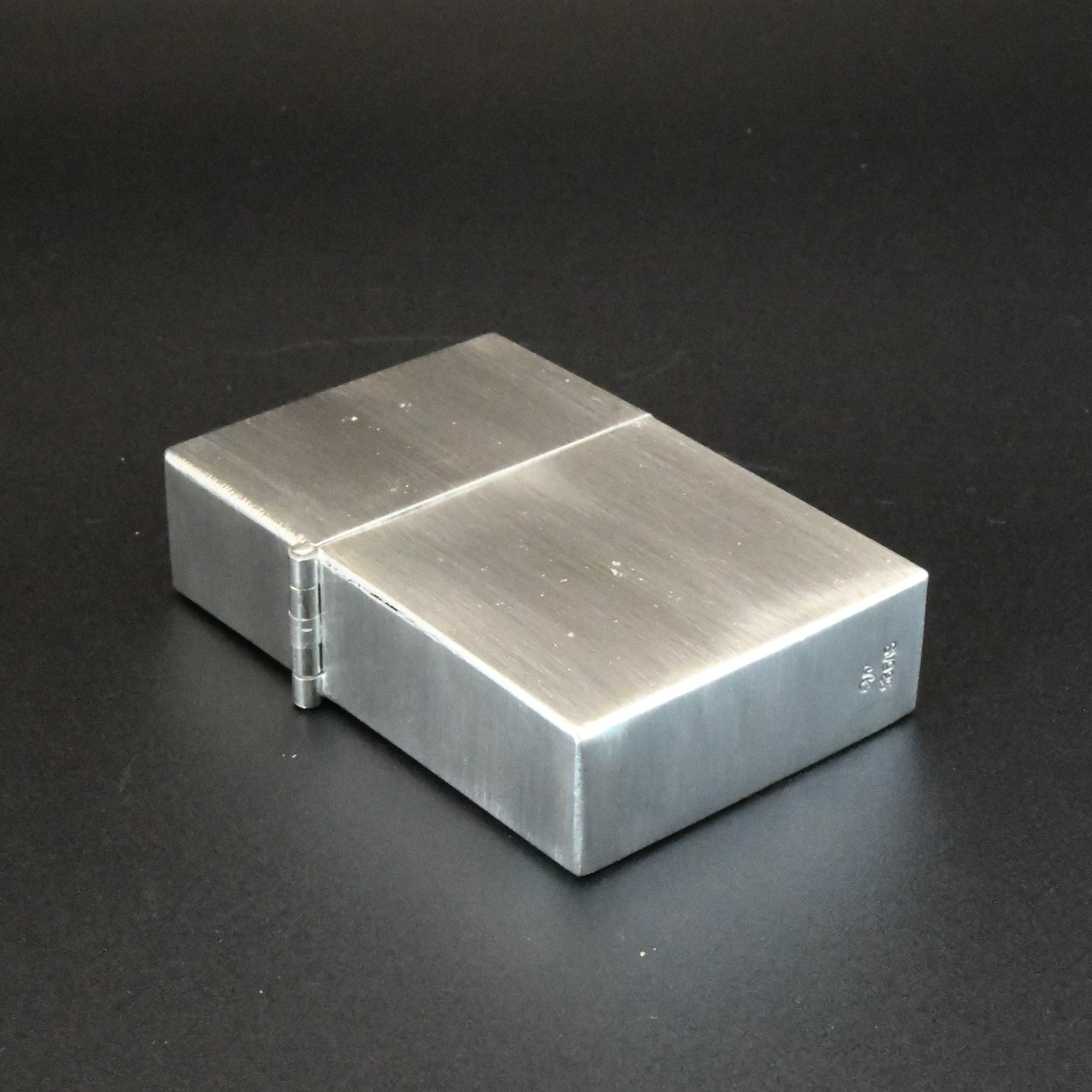 Encendedor de caja de plata hecho a mano

Encendedor de combustible con diseño de caja articulada estilo Zippo.

Fabricada con lámina de plata de ley 925 de 1 mm de grosor. 
Es pesado y tiene un verdadero carácter de calidad.
La bisagra está
