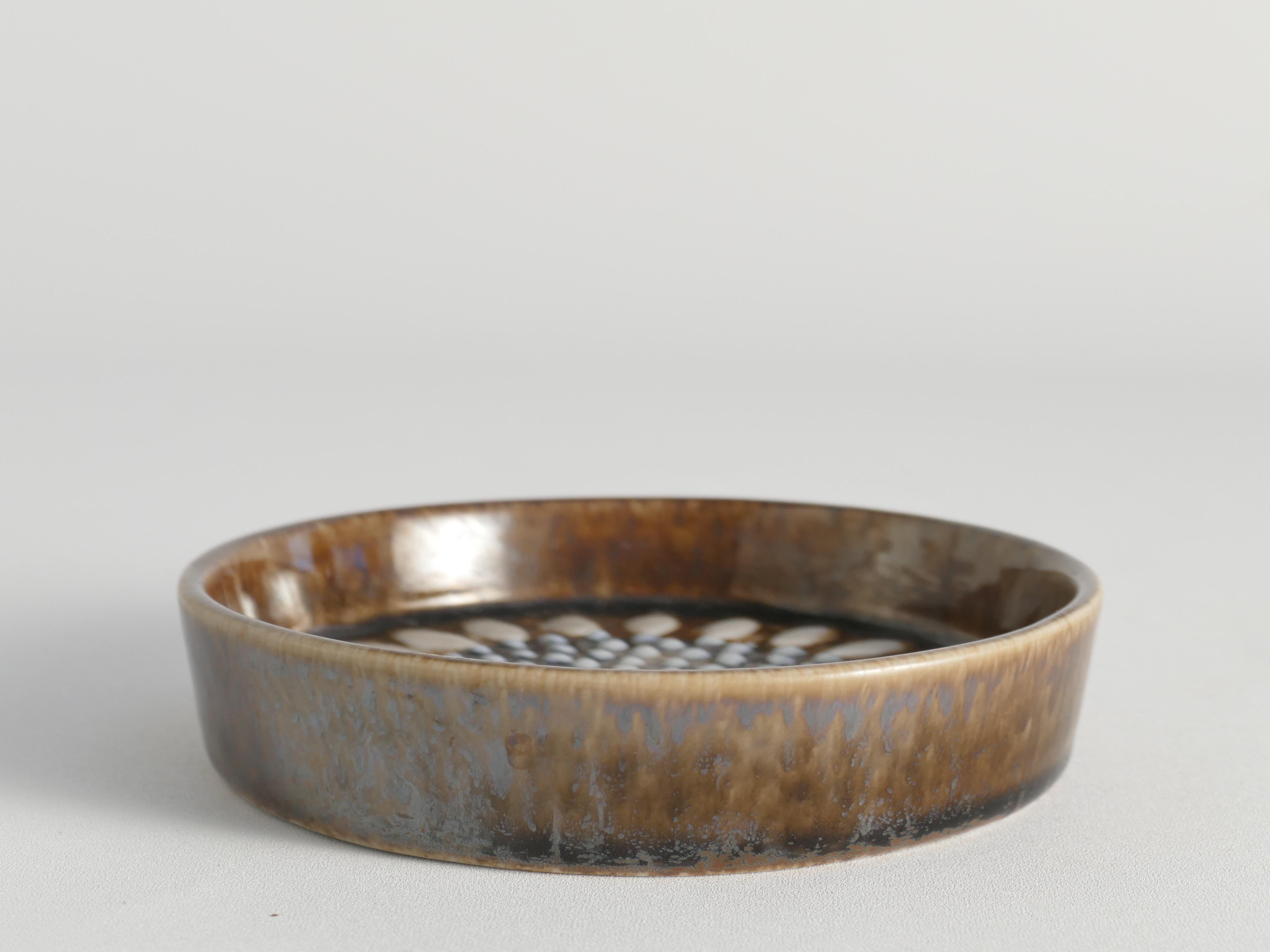 Diseñado por Sylvia Leuchovius y producido por la renombrada firma sueca Rörstrand, este artículo muestra su estilo único, influido por diseñadores finlandeses como Birger Kaipianen y Rut Bryk. Aunque Sylvia no sea tan famosa como Lisa Larson, su
