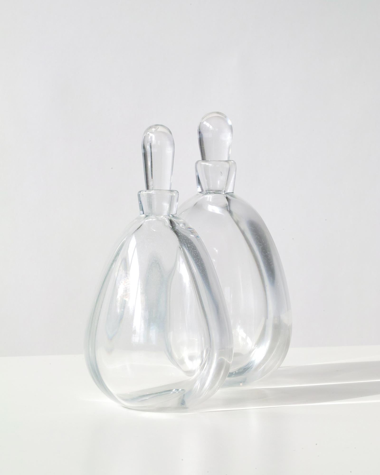 Wir bieten Ihnen dieses außergewöhnliche und seltene Paar früher dekorativer Kunstglasflaschen von Vicke Lindstand für Orrefors, Schweden. Jede handgefertigte/mundgeblasene Flasche ist einzigartig und so gestaltet, dass sie sich gegenseitig ergänzt.