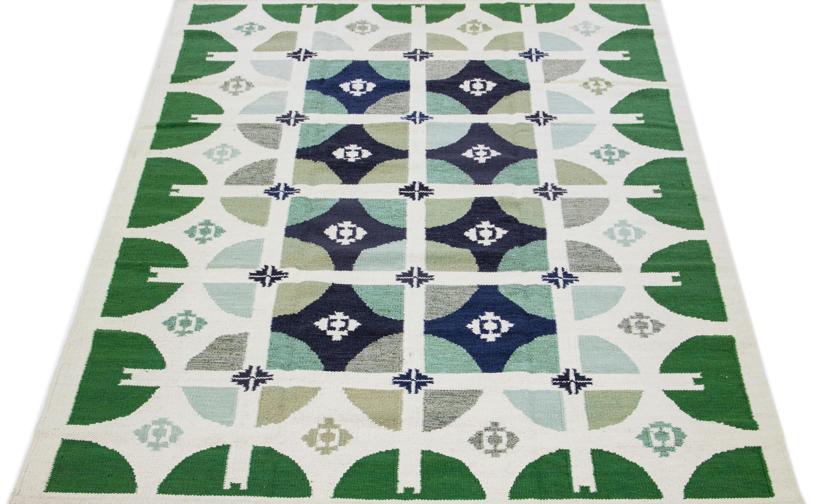 This contemporary wool rug, influenced by Swedish design, showcases an elegant ivory background. This Swedish-style rug is a true beauty, adorned with a stunning green geo abstract pattern.

 This rug measures 9'2