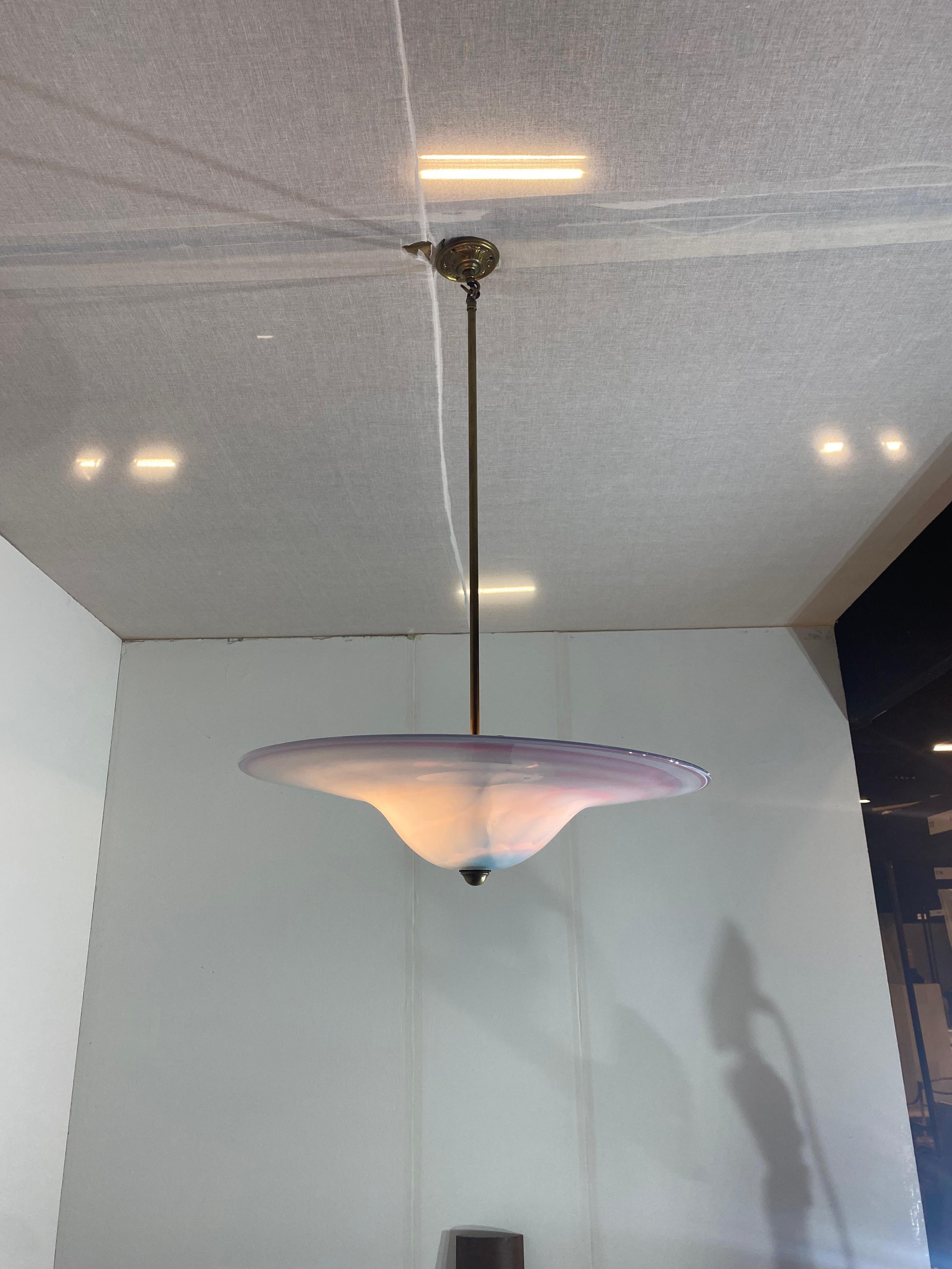 Eine elegante italienische Deckenleuchte aus Murano in Pastellfarben, die von einer zentralen Messingstange getragen wird.
UFO-Form mit Pastellfarben in Rosa und Babyblau, die sich zu einem Strudel vermischen.

Ein weiteres ähnliches Modell ist