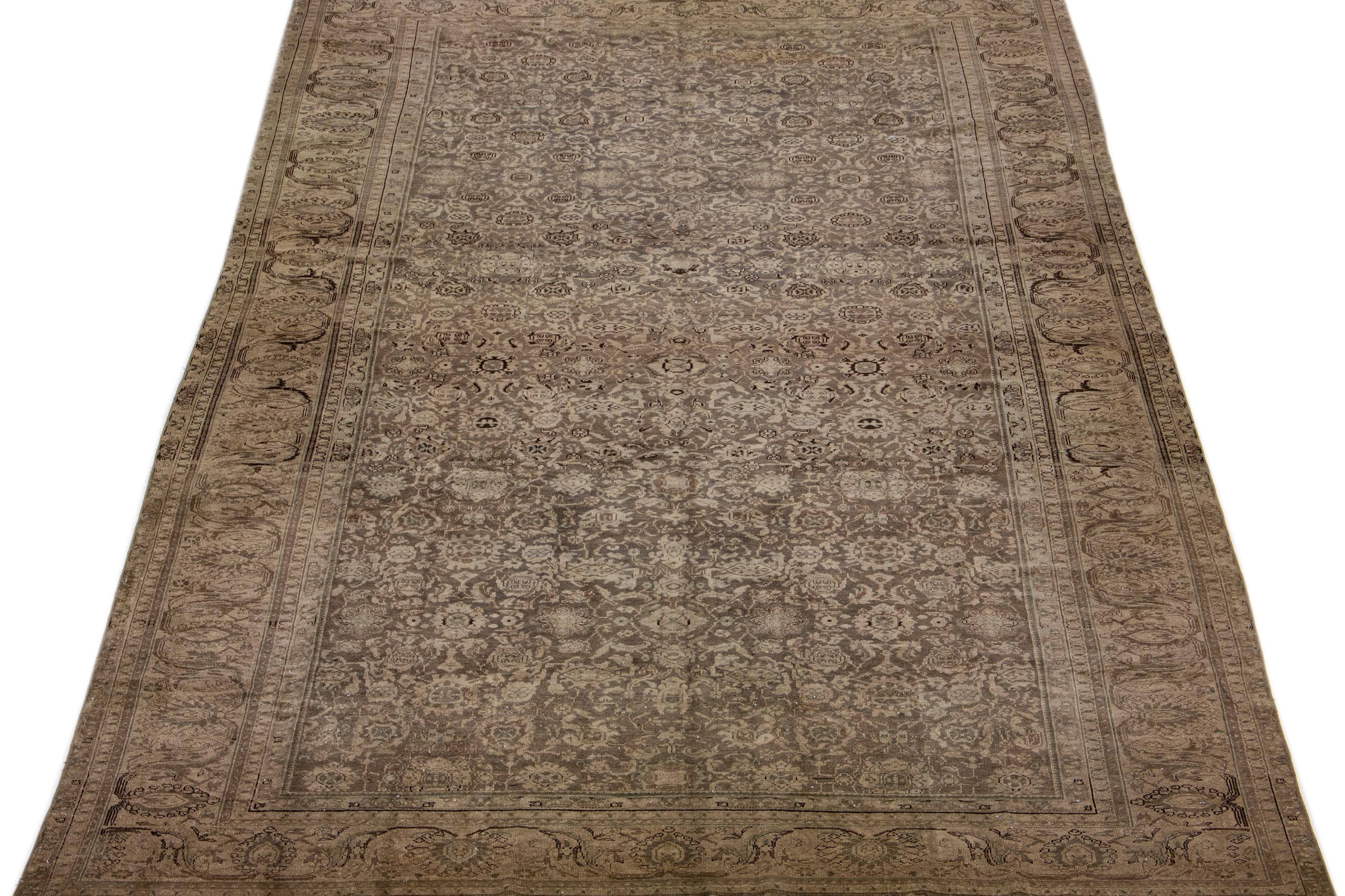 Ce tapis Tabriz antique présente un champ de couleur marron et une construction exquise en laine nouée à la main, complétée par des touches de bleu dans un motif floral sur toute la surface.

Ce tapis mesure : 10'6