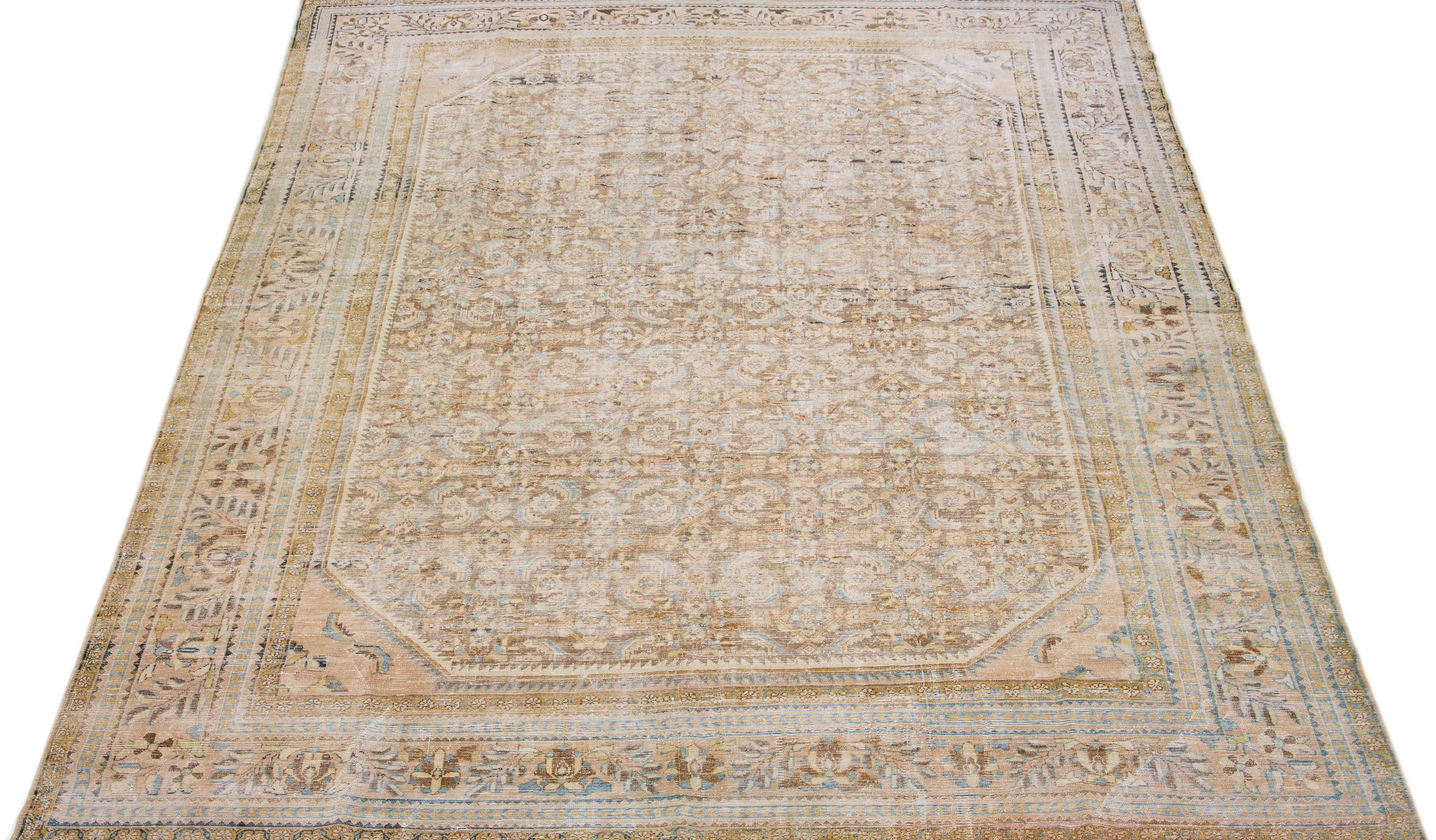 Beautiful antique Malayer hand-knotted wool rug with a tan color field. This Persian rug has blue, brown, and goldenrod accents in a gorgeous traditional floral design.

This rug measures: 9'10