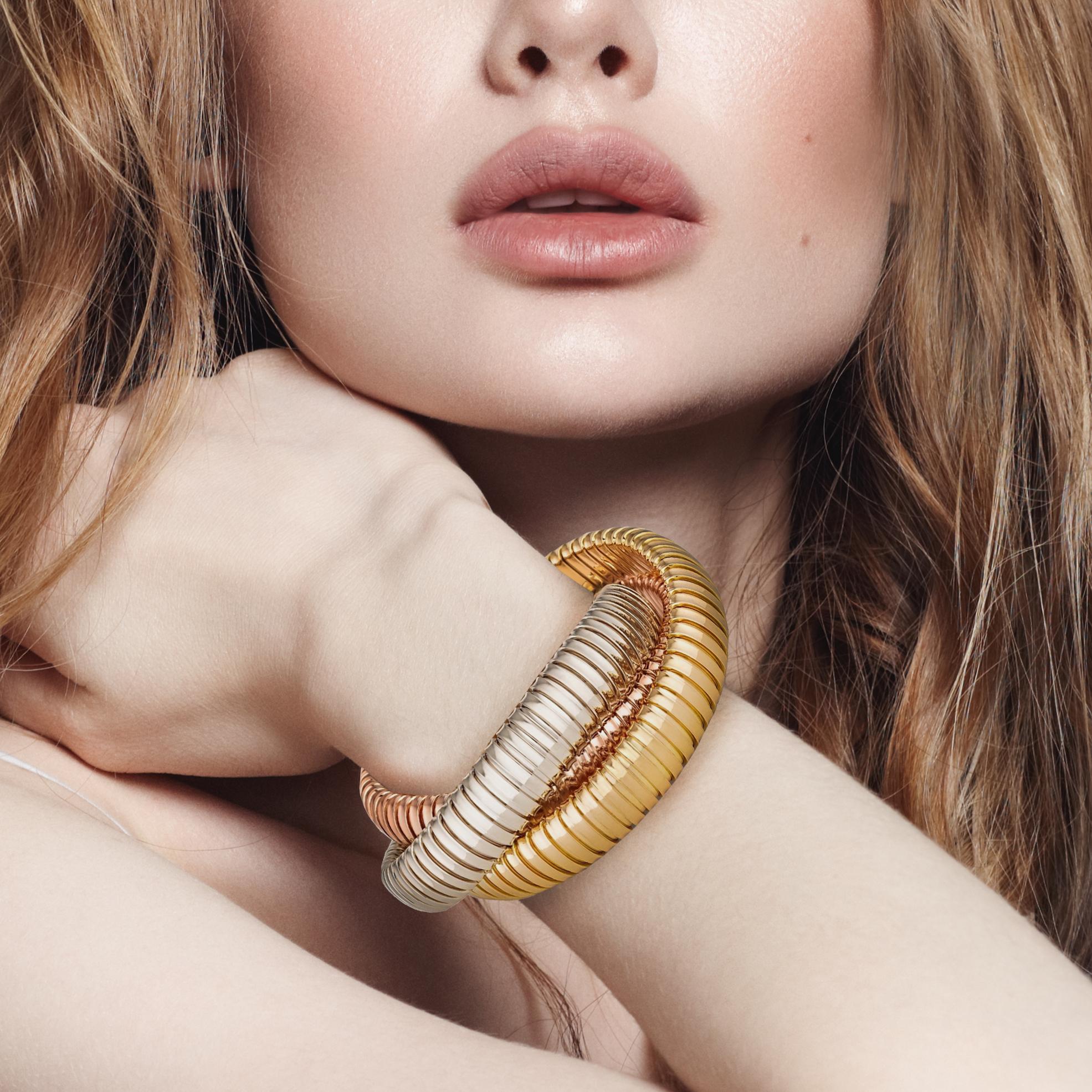 With a timeless but modern style, this chic intertwined three strand 12mm tubogas rolling bangle bracelet was originally inspired by the flexible automotive gas tubing of the 1920’s.  Translated into luxurious 18 karat white, rose and yellow gold