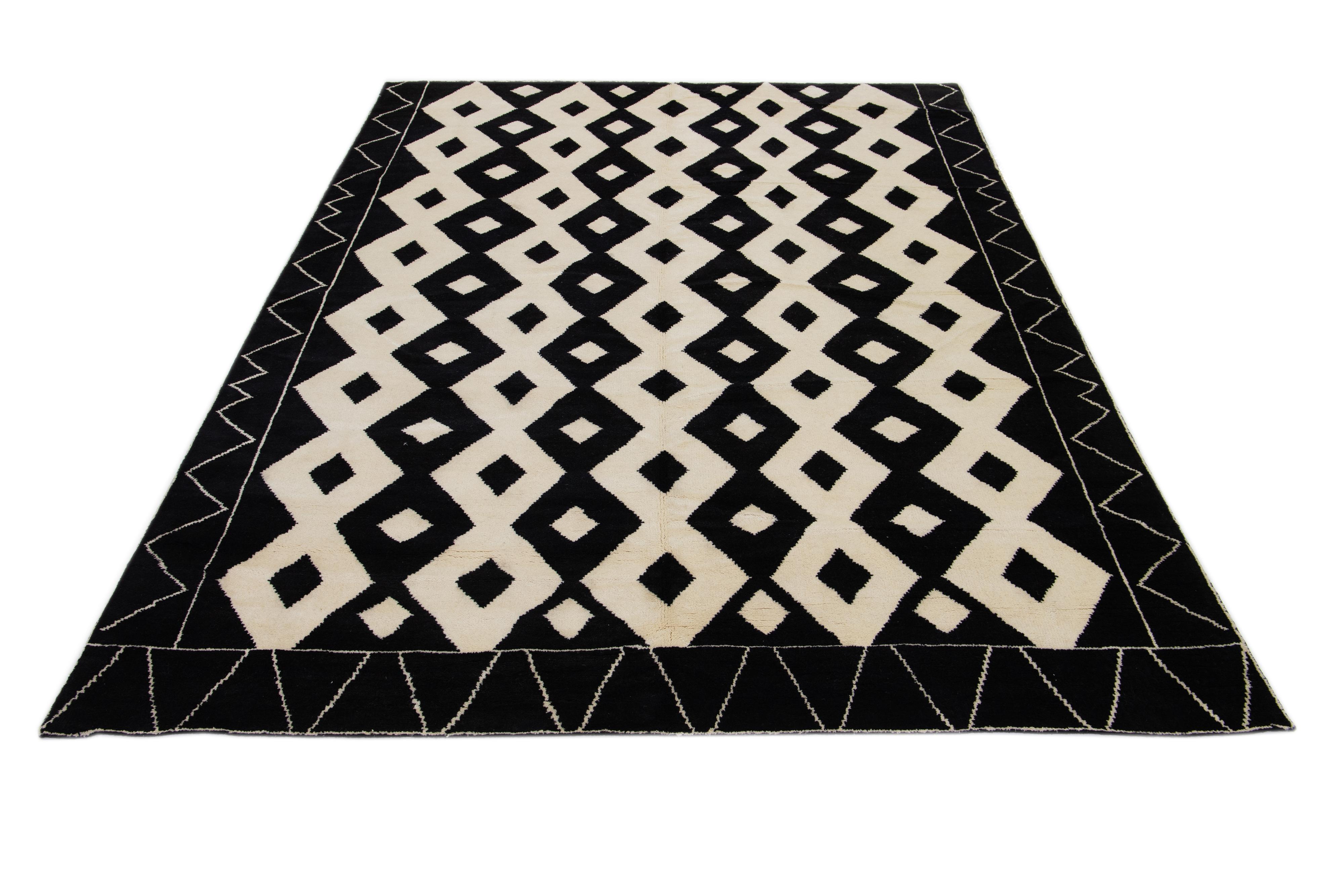 This hand-knotted wool rug features an exotic Moroccan tribal pattern, primarily in ivory hues, which beautifully contrasts with a captivating black background. This rug has a stunning tribal artwork of contemporary style.

This rug measures 9' x