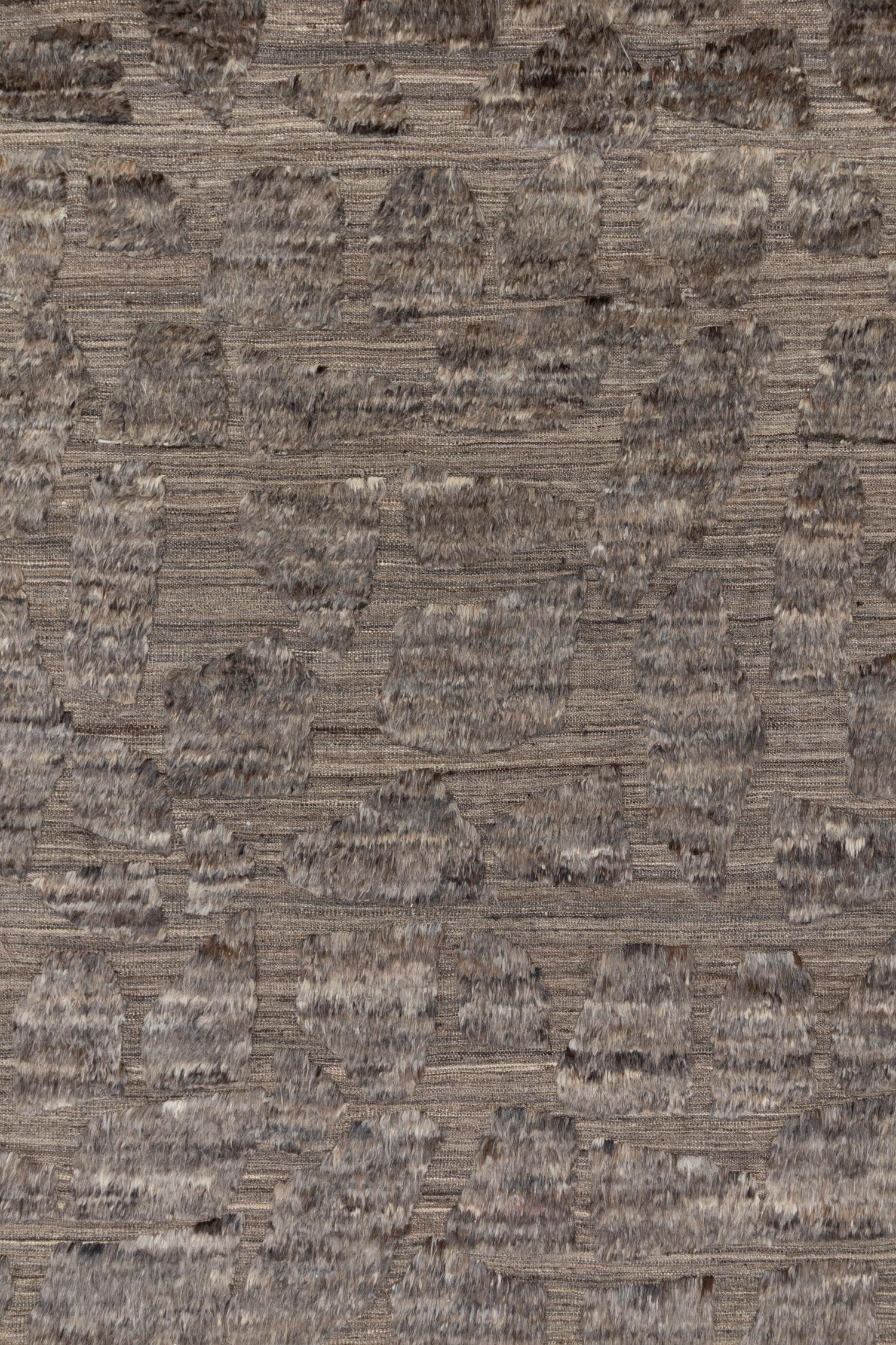 Dieser handgefertigte Teppich aus 100 % Wolle zeichnet sich durch ein visuell interessantes Nebeneinander von Hochflor und Flachgewebe aus. Die satten, erdigen Brauntöne sind strukturiert und warm mit schönen Variationen für ein organisches