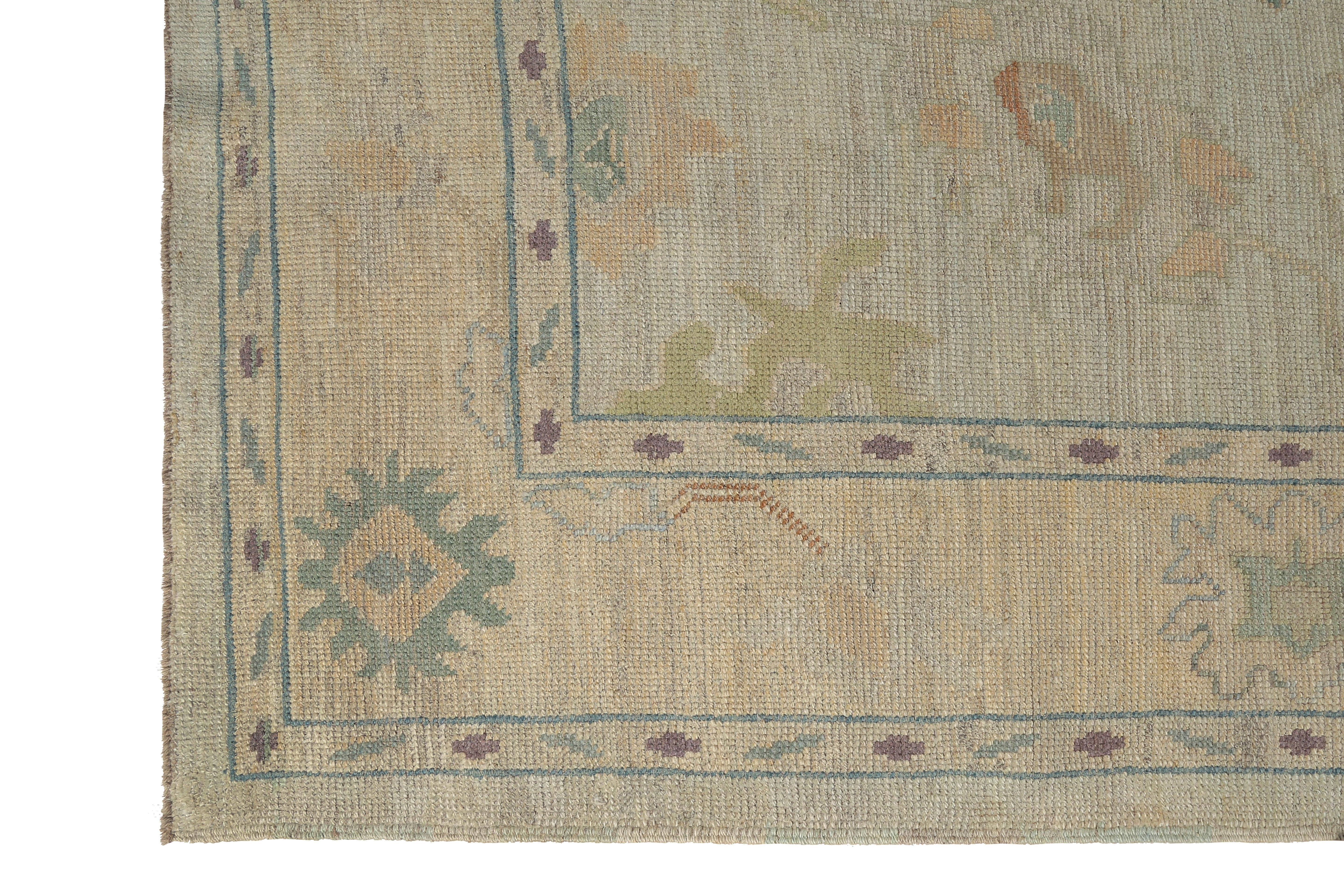 Introducing a stunning handmade Turkish Oushak rug that effortlessly blends modern design with traditional craftsmanship. The light beige background sets the perfect stage for the intricate coral and teal floral motifs, which add a pop of color and