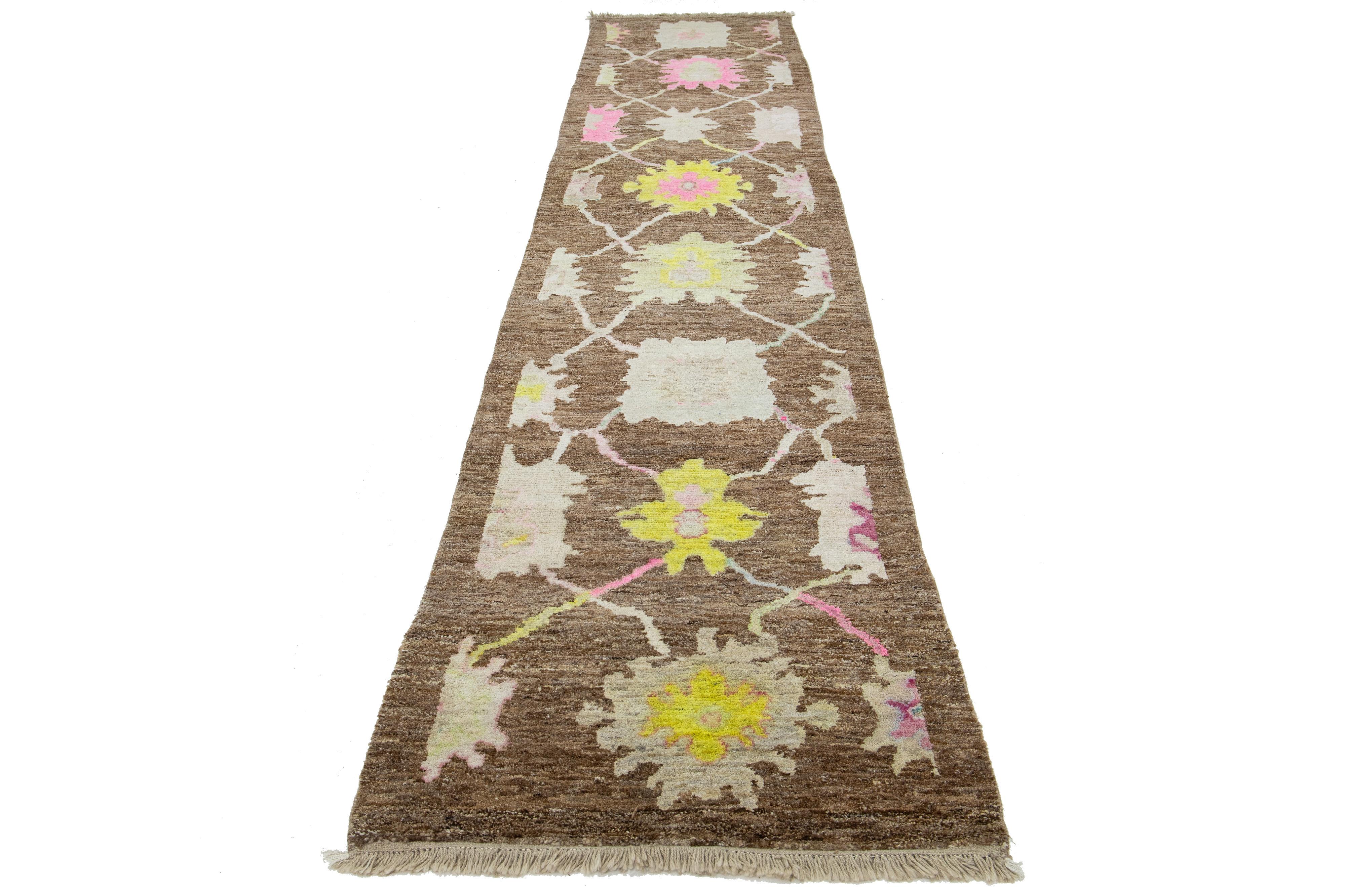 This beautiful modern Oushak hand-knotted wool rug features a brown color field. It is a Turkish piece with stunning accent colors of blue, yellow, pink, and pink, all woven into a gorgeous all-over floral design.

This rug measures 3'1