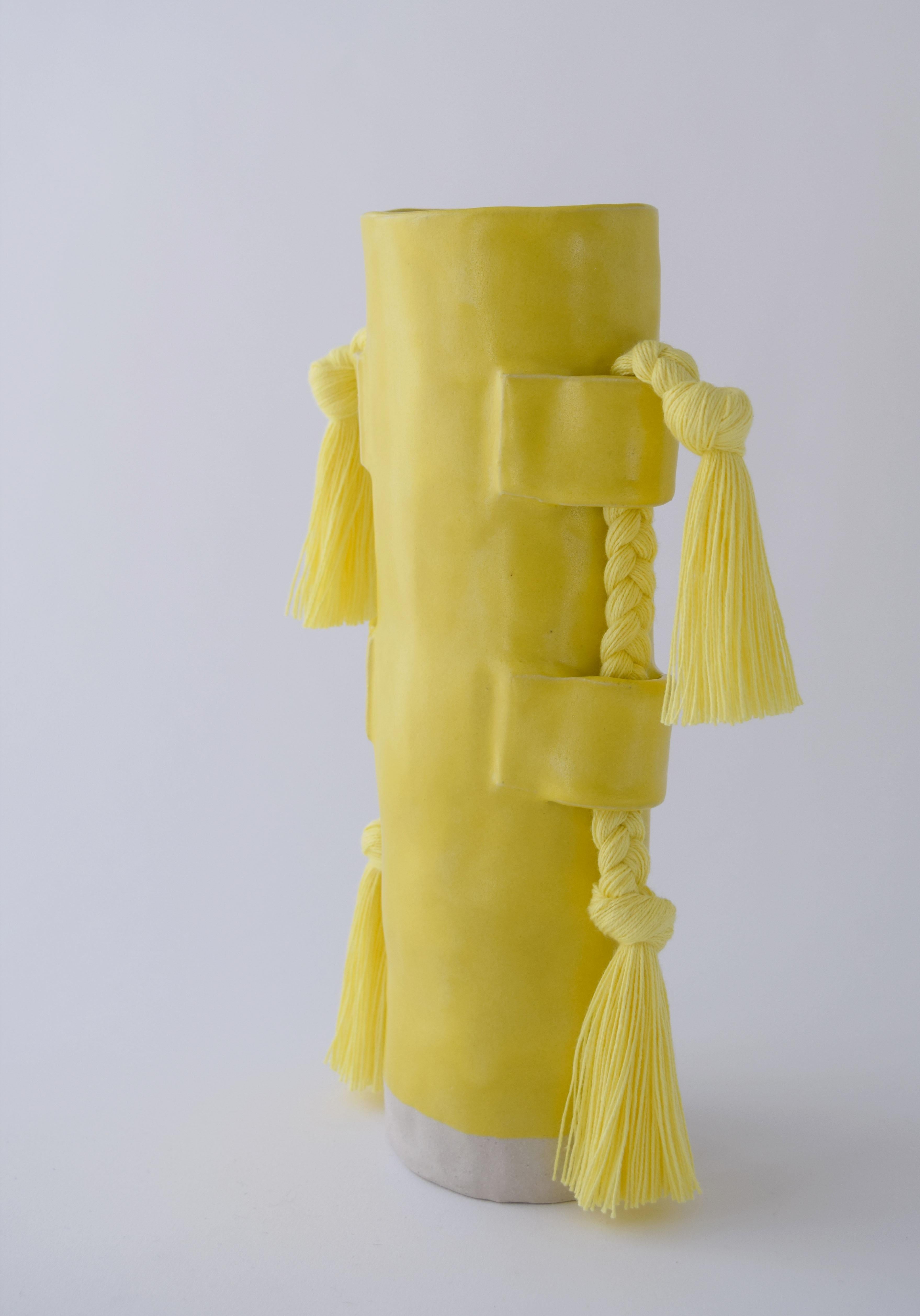 Vase #504 by Karen Gayle Tinney

Hand formed stoneware vase with satin yellow glaze. Inside is glazed yellow and will hold water, please take care not to damage fringe areas. Yellow cotton fringe braids with fringe are applied to the outside of