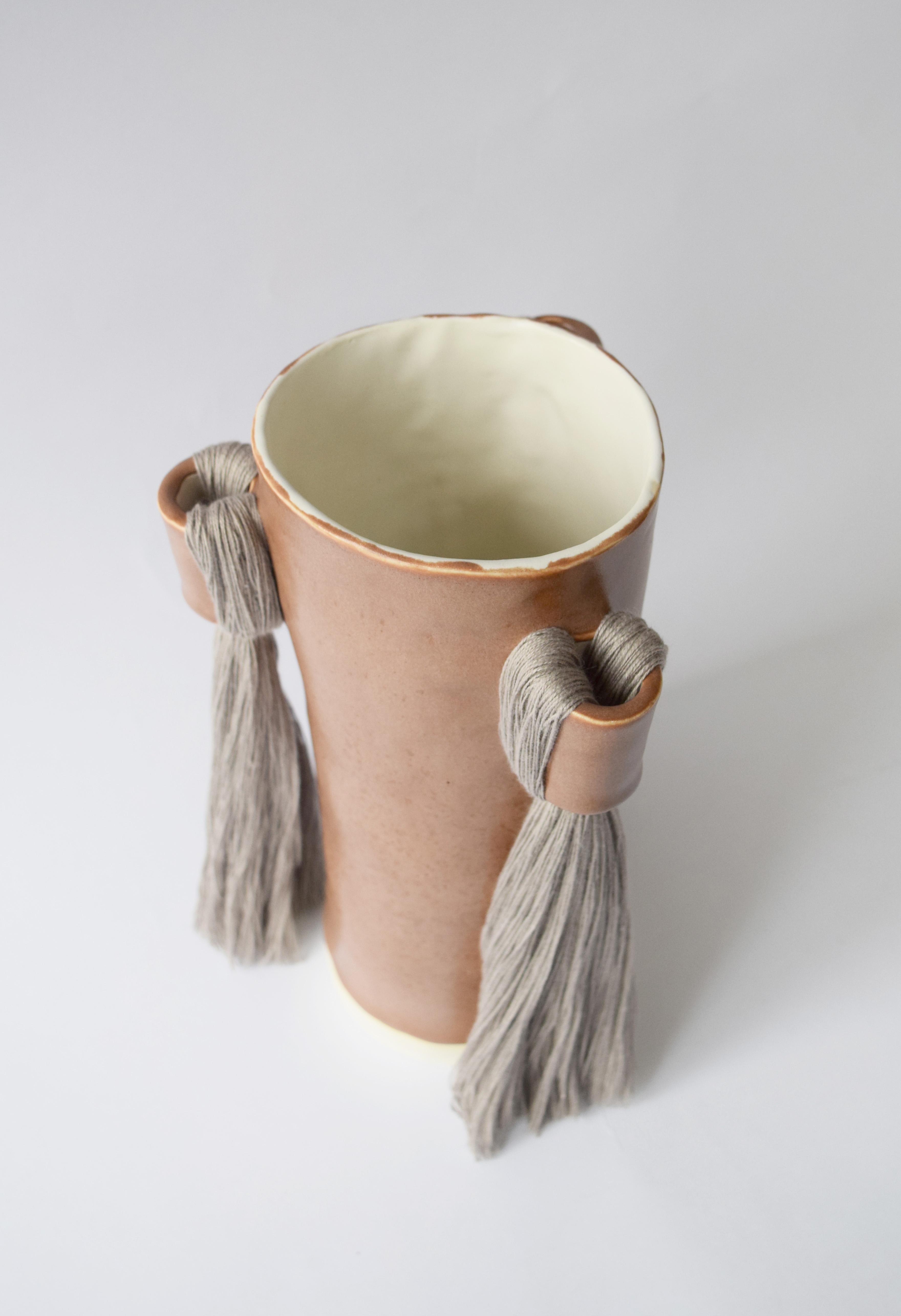 Vase #607 by Karen Gayle Tinney

Hand formed stoneware vase with brown satin glaze. Inside is glazed white and will hold water - please take care not to damage fringe areas. Light gray cotton fringe is applied in 3 areas around the outside of the