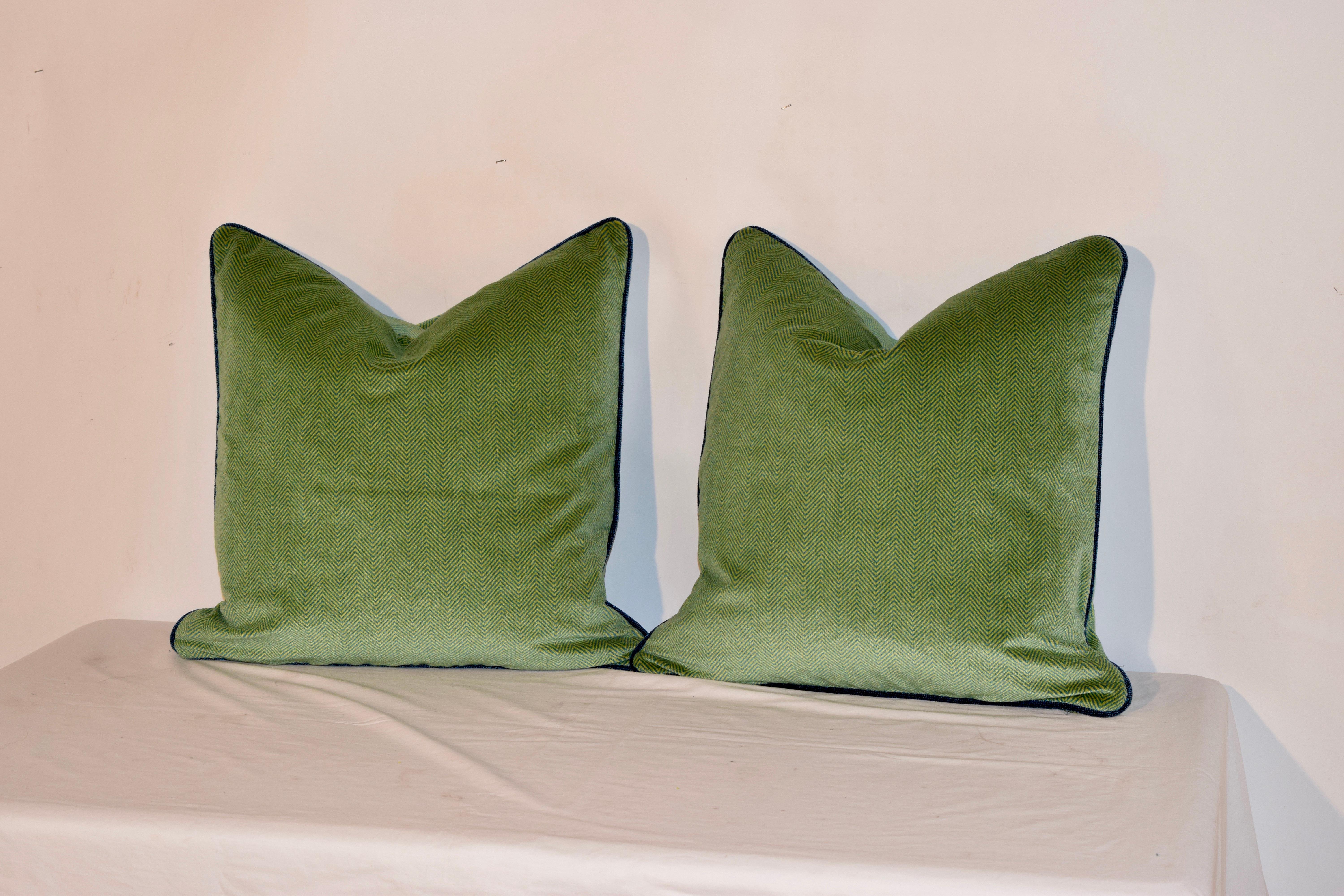 Hand sewn pillows in a blue and green herringbone pattern and contrasting blue velvet cording. Hidden zippers. Feather inserts are removable. Made in North Carolina.