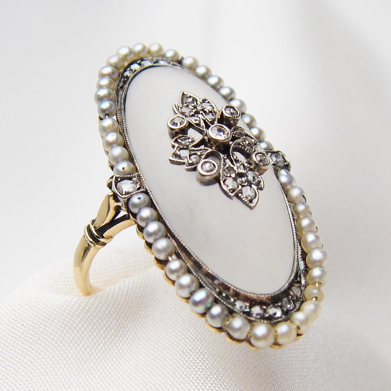 This regal handmade Victorian ring features a fantastic oval, cabochon-cut camphor glass piece decorated with a silver leaf motif, bead- and bezel-set with 15 rose-cut diamonds and five old European-cut diamonds. Bead-set in a halo around the glass