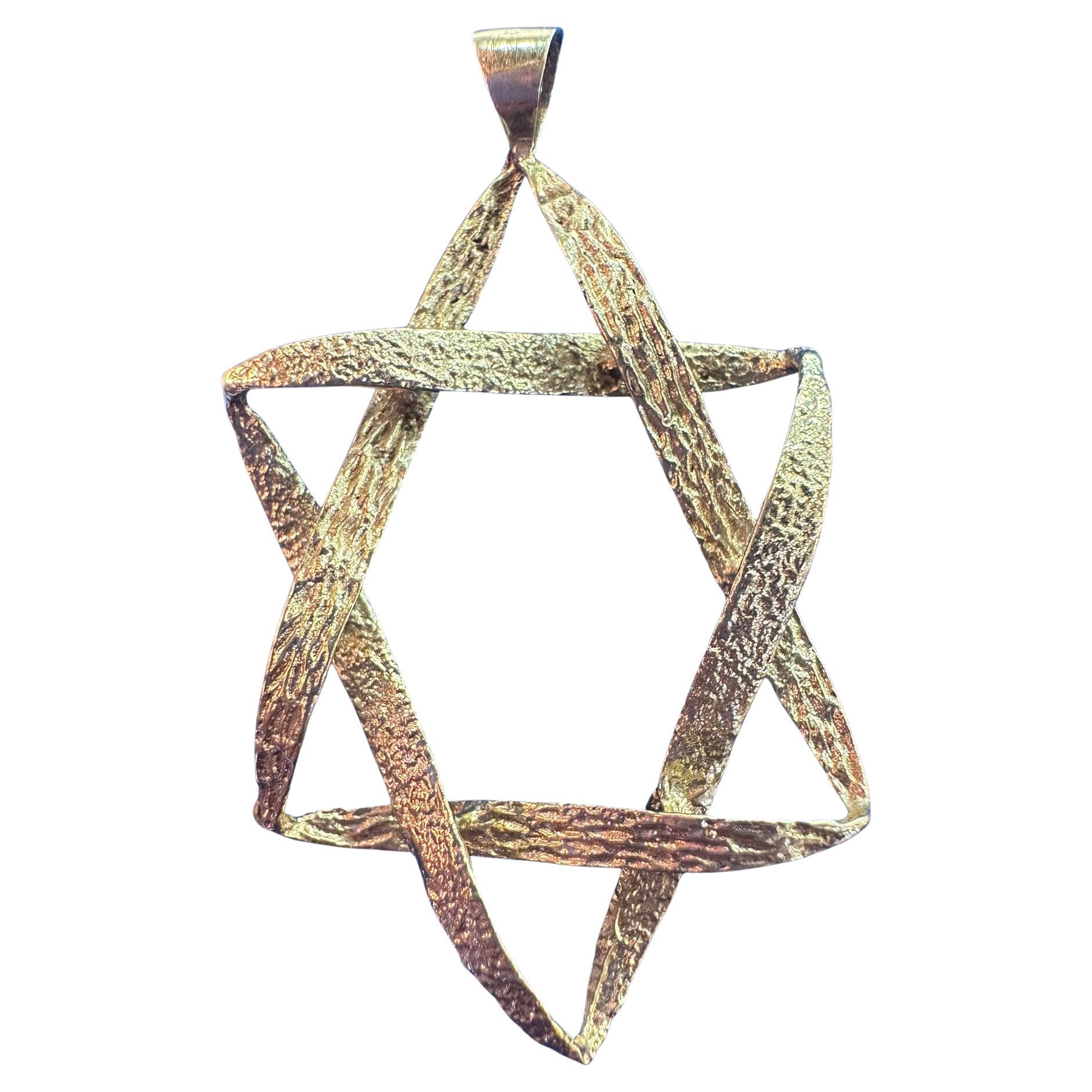 This is a handmade vintage pendant crafted from 14k gold, weighing 4 grams. The pendant features a textured, interwoven Star of David design, giving it a distinctive and artistic appearance. The gold has a hammered or organic finish, adding depth