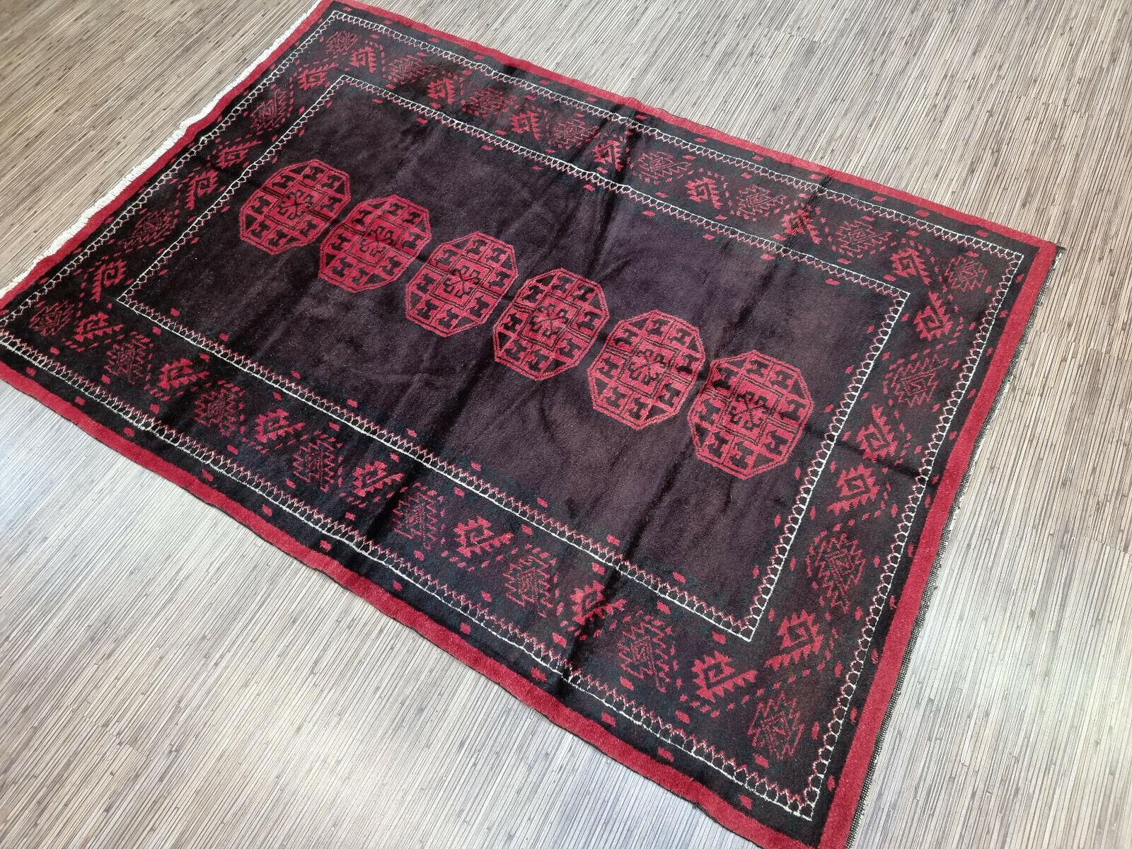 Tauchen Sie Ihren Raum mit unserem handgefertigten afghanischen Baluch-Teppich im Vintage-Stil in die Kunst der Jahrhundertmitte ein. Dieses exquisite Stück, das in den 1950er Jahren von geschickten Kunsthandwerkern sorgfältig hergestellt wurde,
