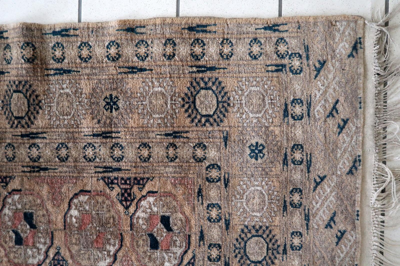 Questo tappeto afghano Baluch vintage degli anni '60 è uno splendido esempio di artigianato tradizionale. Con una larghezza di 4,1 piedi (126 cm) e una lunghezza di 6,5 piedi (199 cm), questo tappeto in lana è in buone condizioni e presenta un