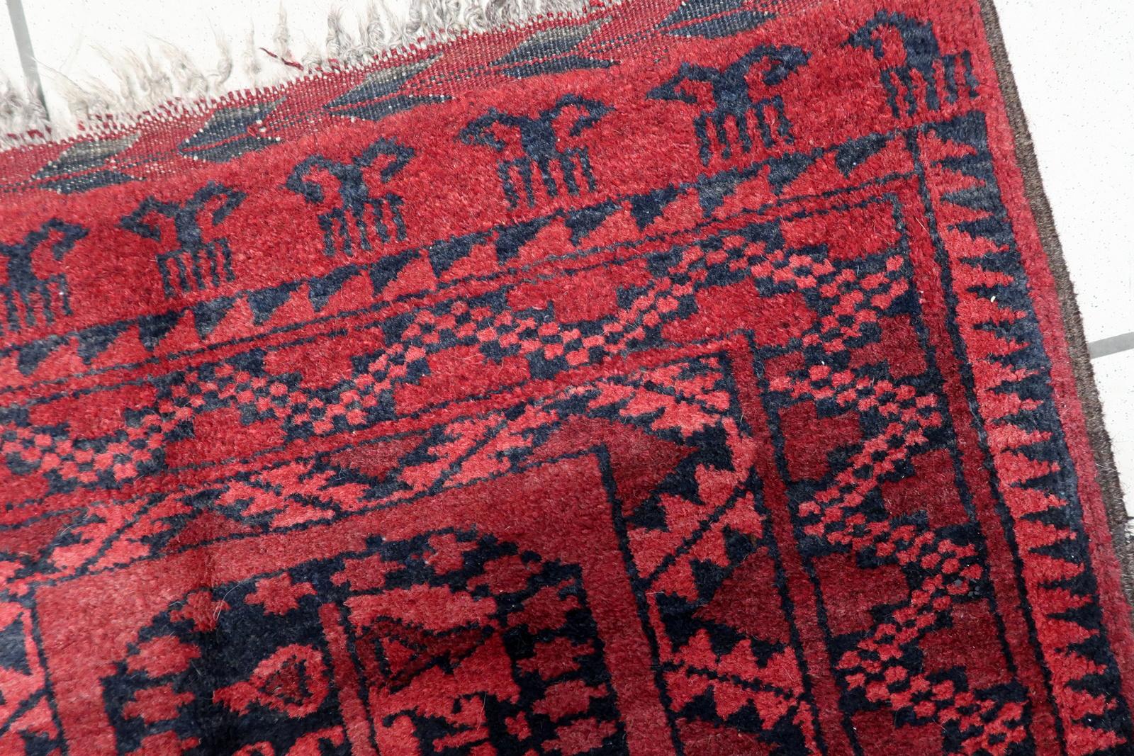 Immerse your living space in the rich history and artistry of our Handmade Vintage Afghan Ersari Rug from the 1940s. Measuring 2.2 feet by 2.9 feet (70cm x 89cm), this captivating rug is a true testament to the skilled craftsmanship and cultural