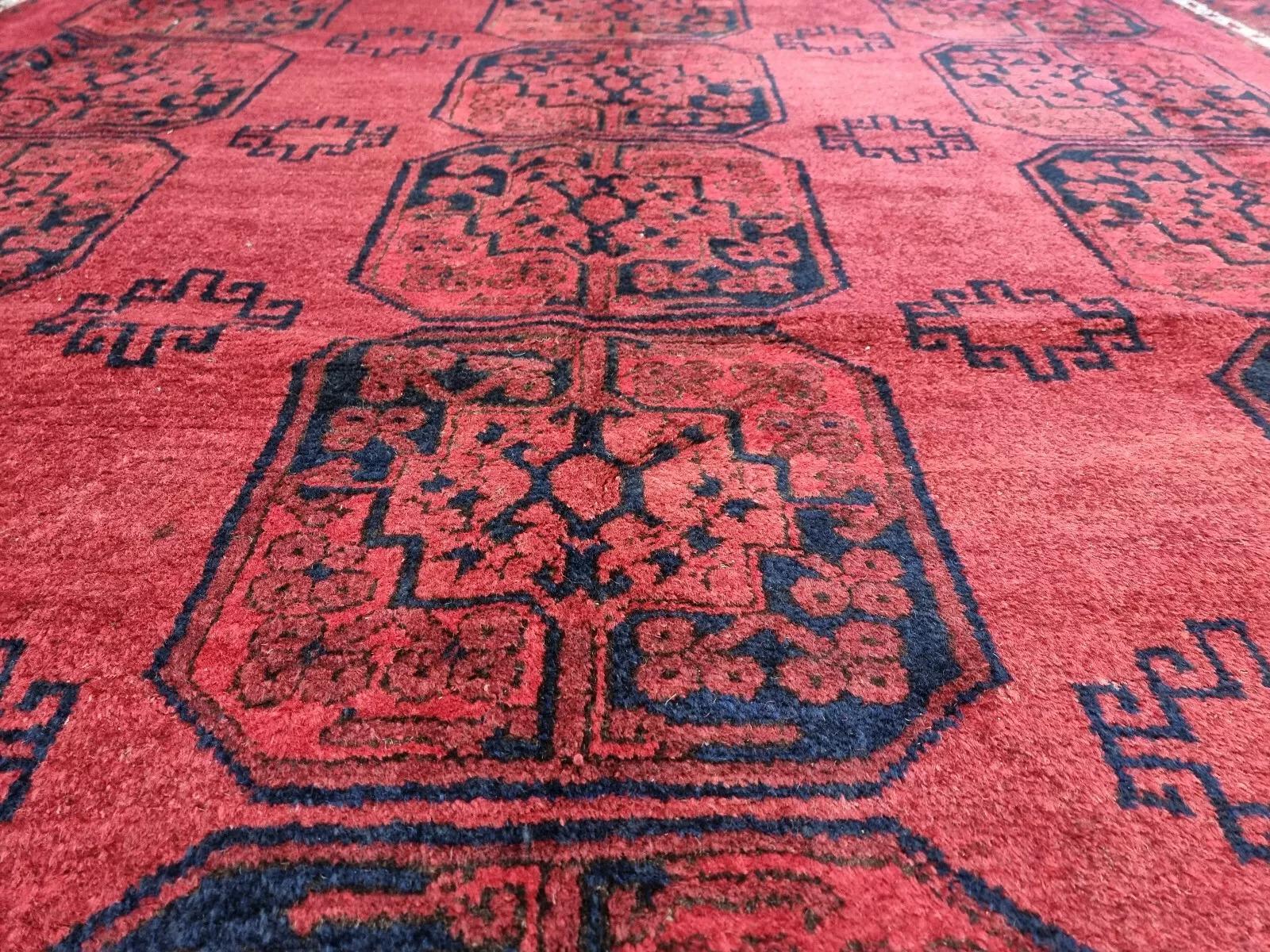 Dieser außergewöhnliche afghanische Teppich im Vintage-Stil ist ein markantes, handgeknüpftes Stück aus 100 % Wolle. Mit seinen satten Rottönen und seinem zeitlosen orientalischen Design passt er wunderbar zu jedem Einrichtungsstil und verleiht ihm