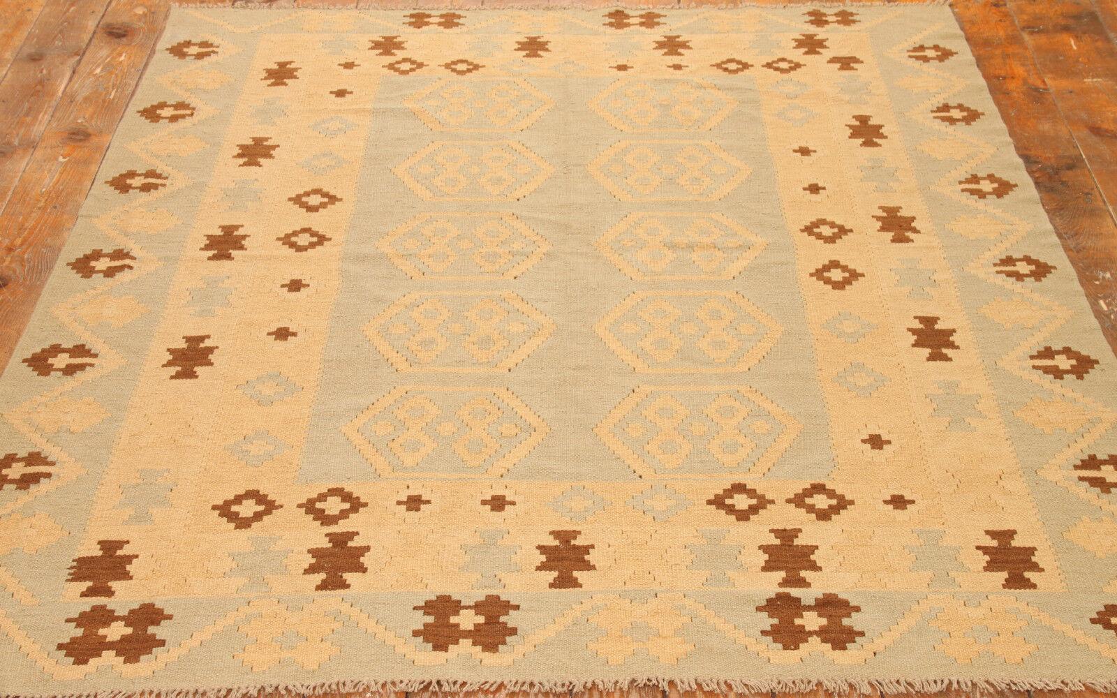 Unveil the timeless beauty of our Handmade Vintage Afghan Flatweave Kilim, a hidden gem from the 1980s. Measuring at 5.8' x 7.9', this kilim showcases a delicate blend of grey and beige colors, adding a touch of understated elegance to your living