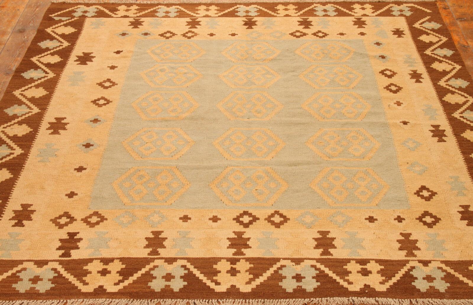 Elevate your space with the captivating elegance of our Handmade Vintage Afghan Flatweave Kilim, a timeless creation from the 1980s. Measuring at 6.5' x 8', this kilim features a mesmerizing geometric design in shades of grey, beige, and brown,