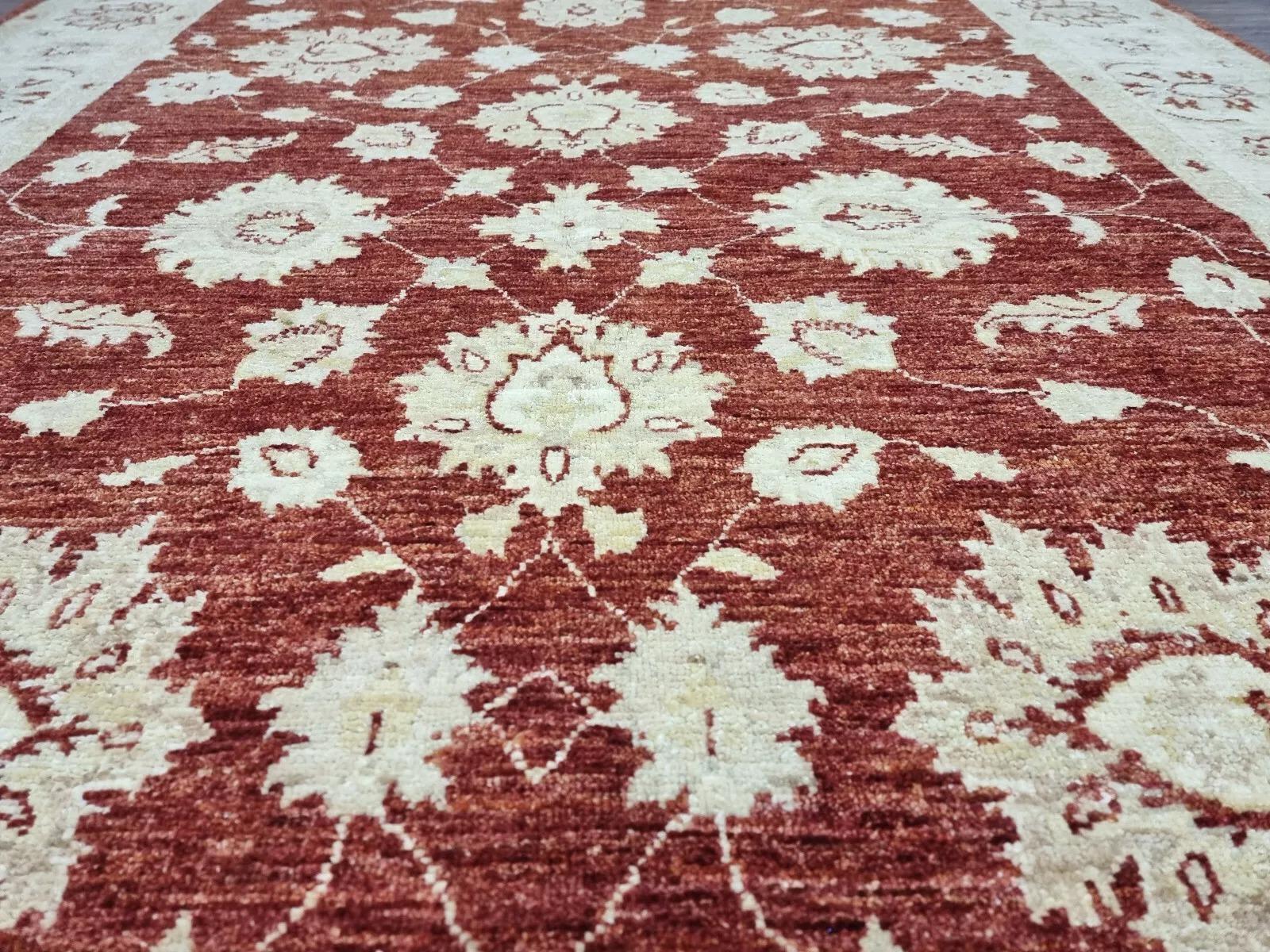 Dieser exquisite afghanische Ziegler-Teppich, der in den 1980er Jahren handgeknüpft wurde, zeichnet sich durch zeitlose Handwerkskunst und ein kompliziertes Design aus. Mit seiner warmen Terrakotta-Farbgebung ist dieser Teppich perfekt geeignet, um