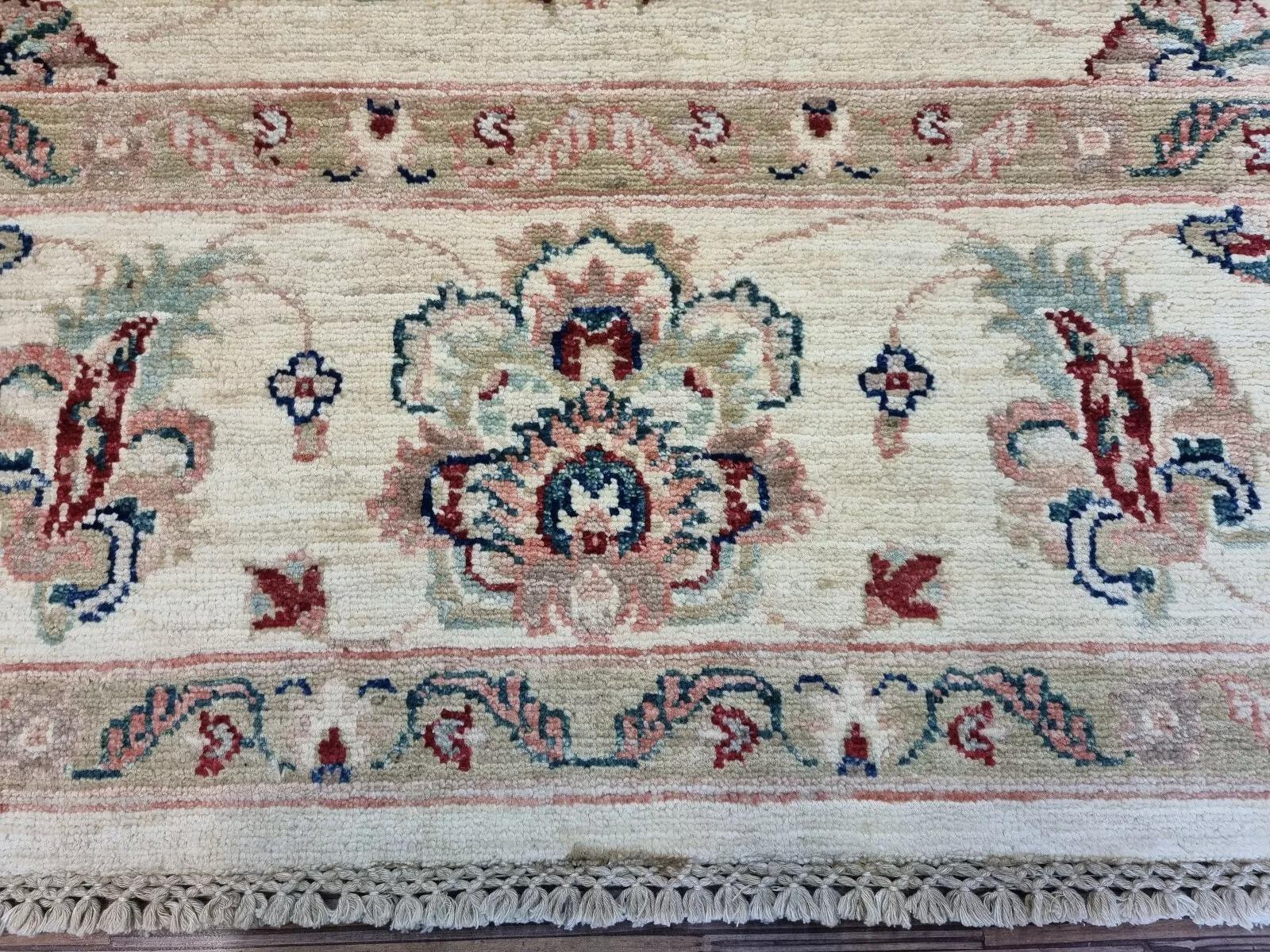 This beautiful Afghan Ziegler rug, hand-knotted in the 1980s, features an elegant beige color palette that perfectly complements both traditional and contemporary interiors. Its intricate craftsmanship and timeless design make it a standout piece