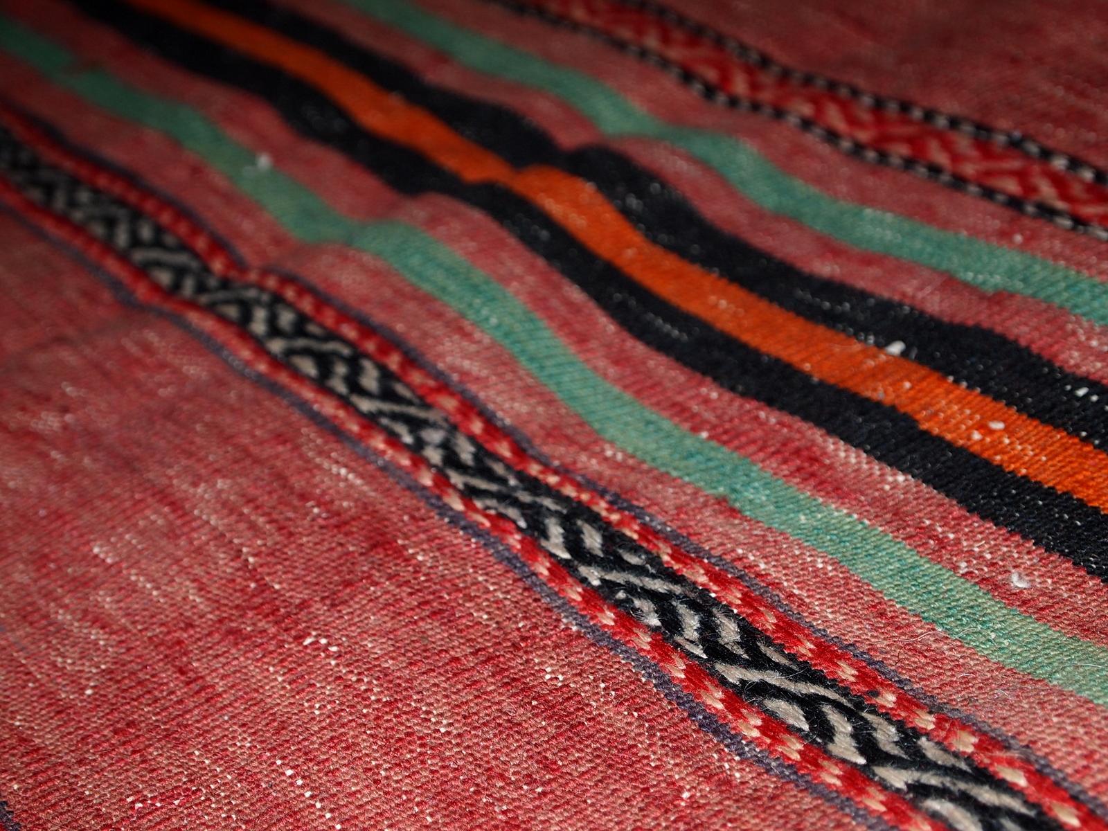 Handgefertigter persischer Kelim im roten Farbton mit Streifen. Dieser Kelim ist im Originalzustand, hat einige Altersspuren.

-Zustand: original, leichte Altersspuren,

-CIRCA: 1940er Jahre,

-Größe: 4,5' x 9,4' (139cm x 288cm),

-MATERIAL: