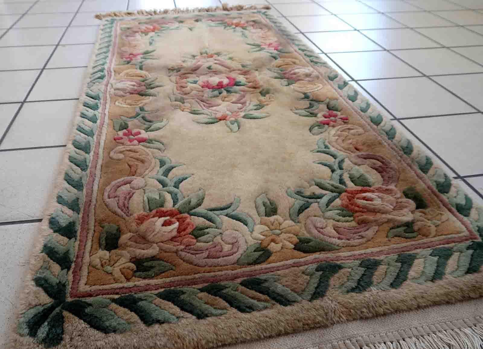 Handmade vintage Art Deco Chinese rug in beige, green and red colors. The rug is from the end of 20th century in original good condition. This rug has classic floral design with the touch of French style.

-condition: original good,

-circa: