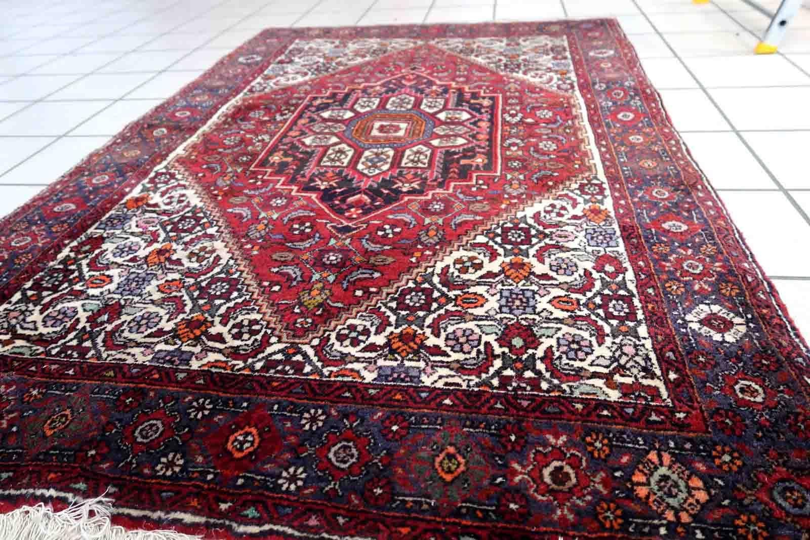 Tappeto vintage in lana Bidjar fatto a mano. Il tappeto risale alla fine del XX secolo ed è in buone condizioni originali. Il tappeto ha un design tradizionale con un grande medaglione al centro. La combinazione di colori è bianca e rossa.

