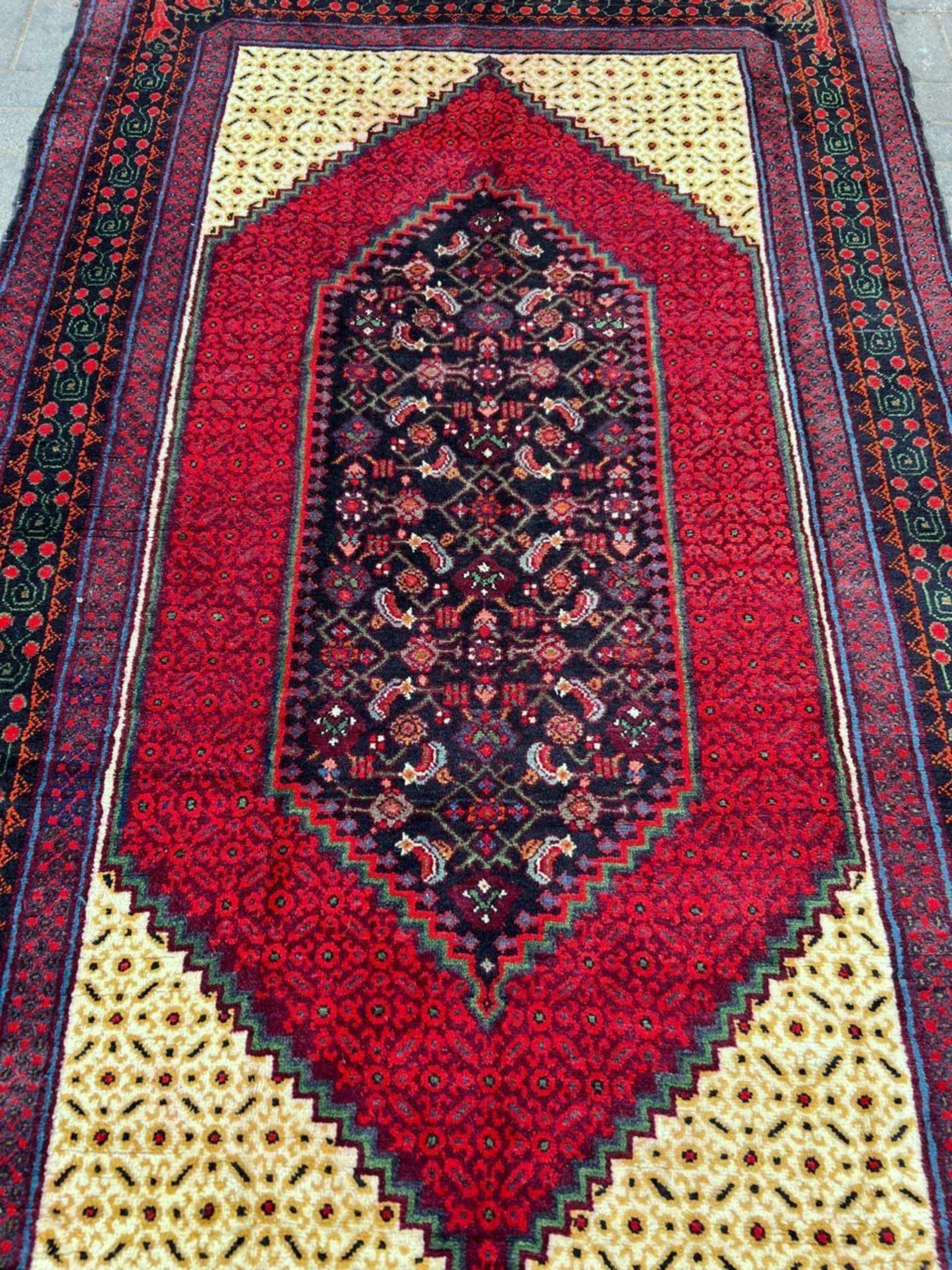 An outstanding example of nomadic weaving, this Vintage Caucasian Kazak Rug is a dramatic floor covering that perfectly anchors a contemporary or traditional space. Hand-knotted from luxurious, durable wool in the 1950s, this large-format Kazak (5’