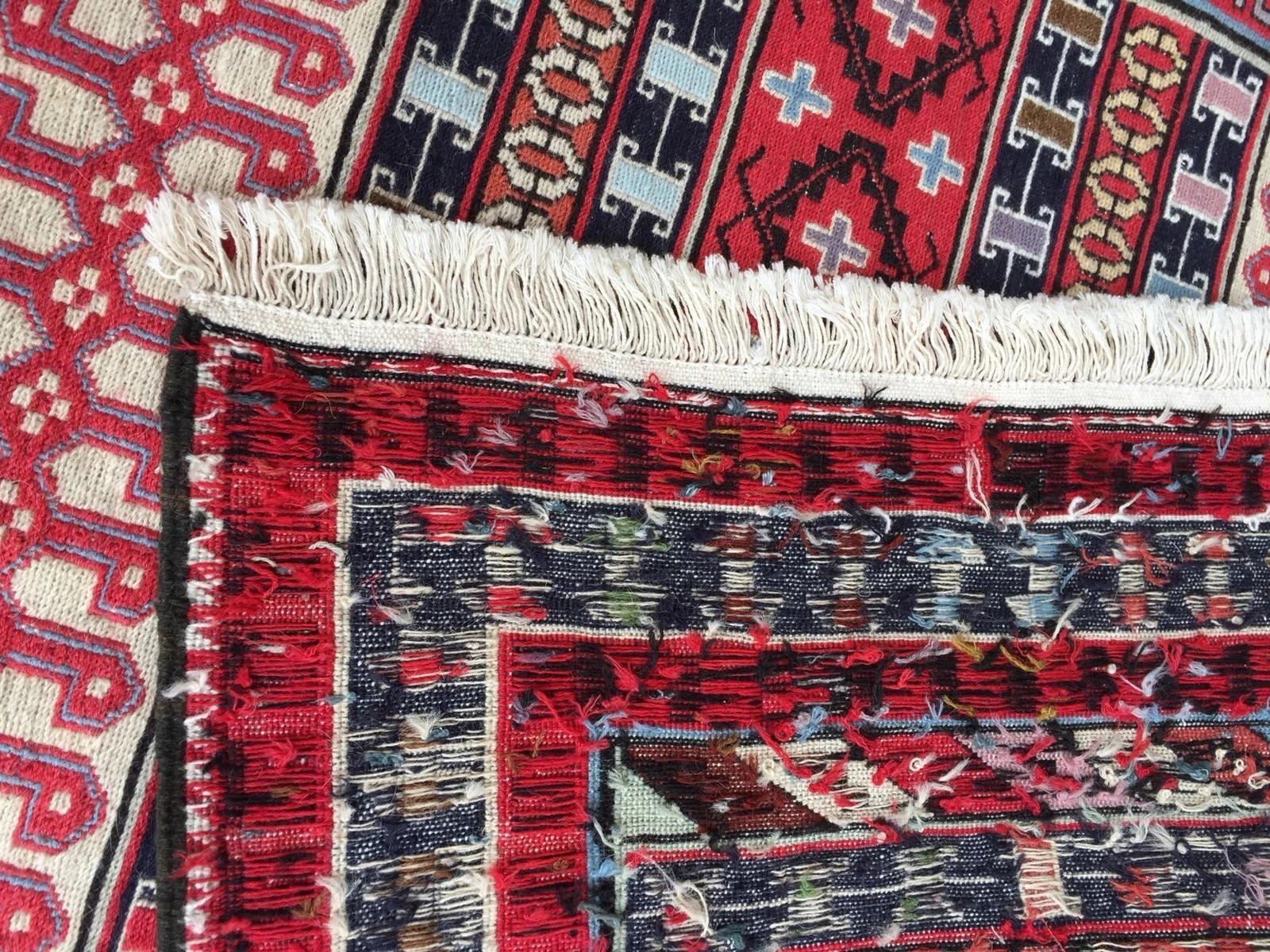 Vibrante arte tribal: Alfombra caucásica Sumak vintage de tejido plano
Sumerge tu espacio en el brioso arte del Cáucaso con esta excepcional alfombra Sumak caucásica vintage hecha a mano, una pieza única de tejido plano originaria de la región y que