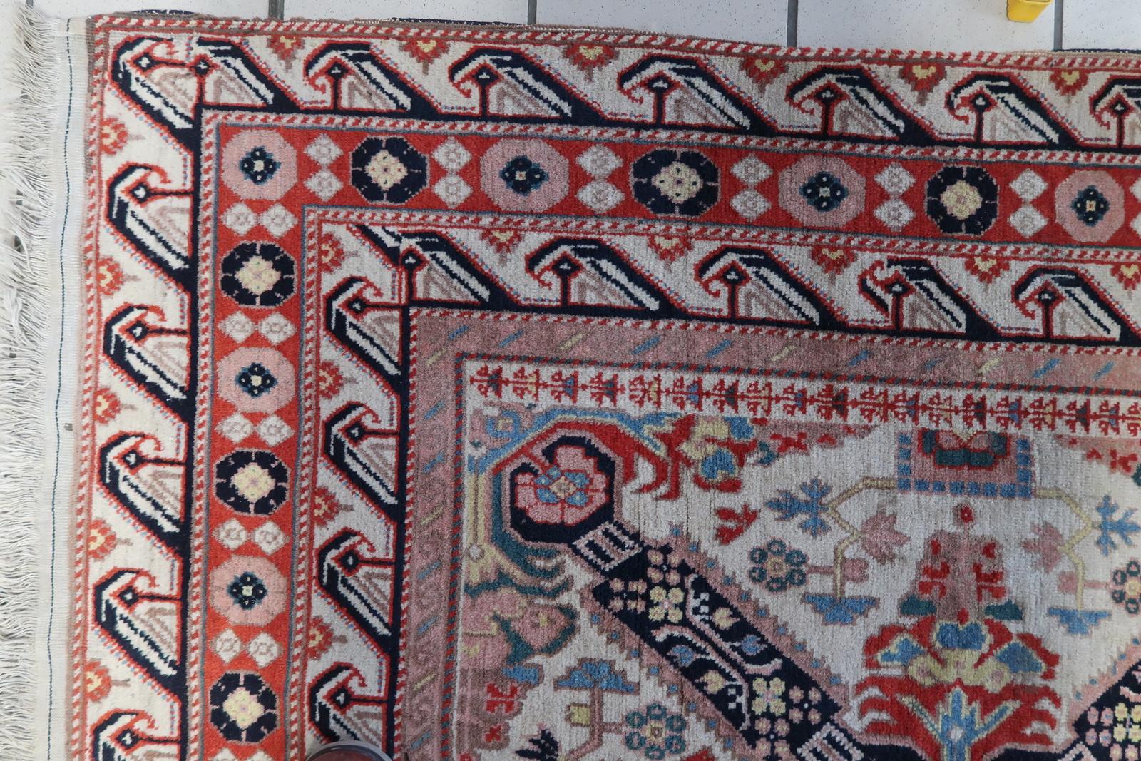 Wir stellen Ihnen unseren exquisiten handgefertigten kaukasischen Zeyhur-Teppich aus den 1950er Jahren vor. Dieser fesselnde Teppich zeigt ein lebhaftes und geschäftiges Design mit weißem Hintergrund und auffälligen Farbakzenten. Mit seinem guten