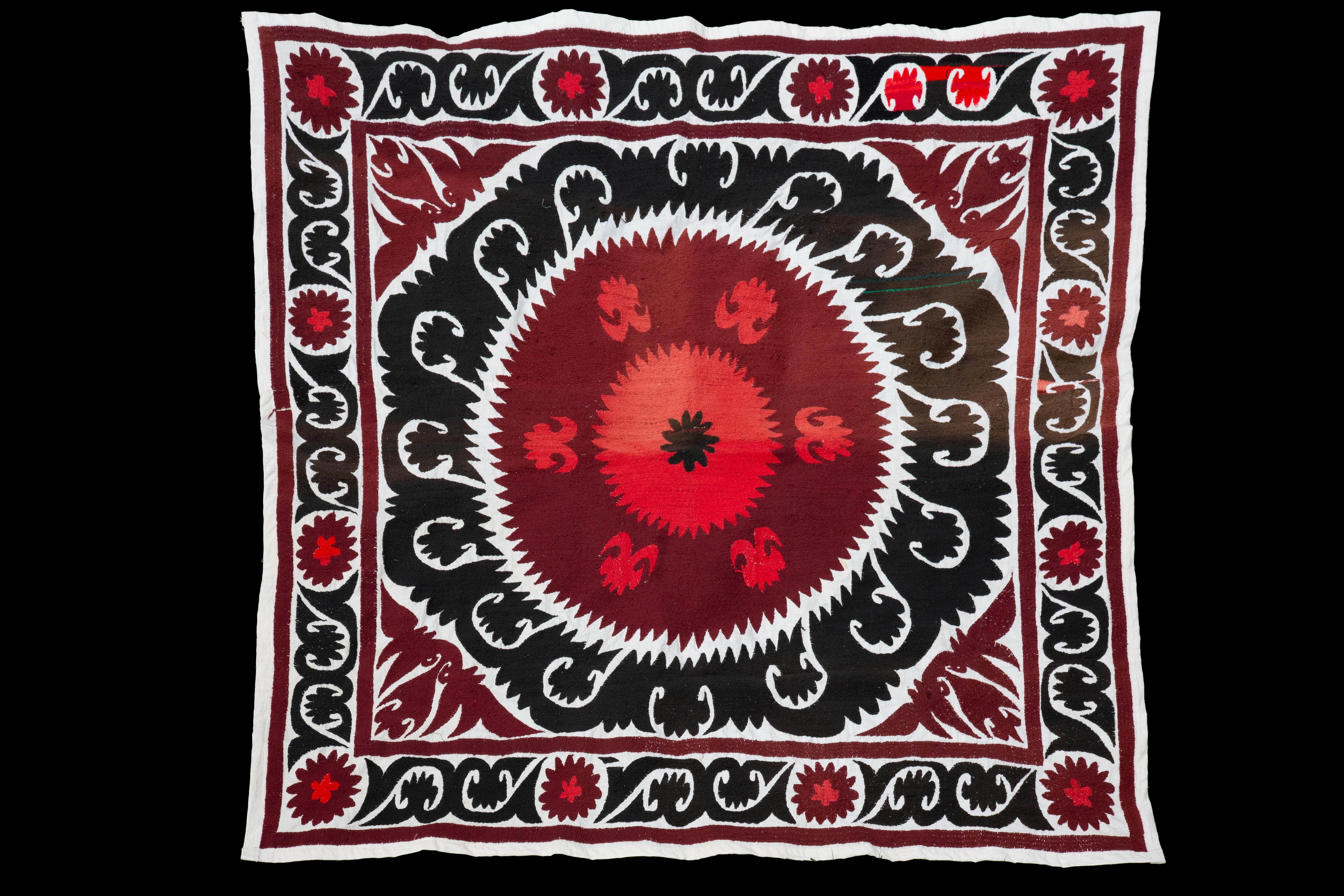 Handmade Vintage cotton suzani, red, charcoal, and black

Richly hand-embroidered vintage Uzbek suzani in iconic black and copper oranges.
Sun burst flowers are ringed with black scrolls on natural cotton.
Cotton embroidery in tight stitches