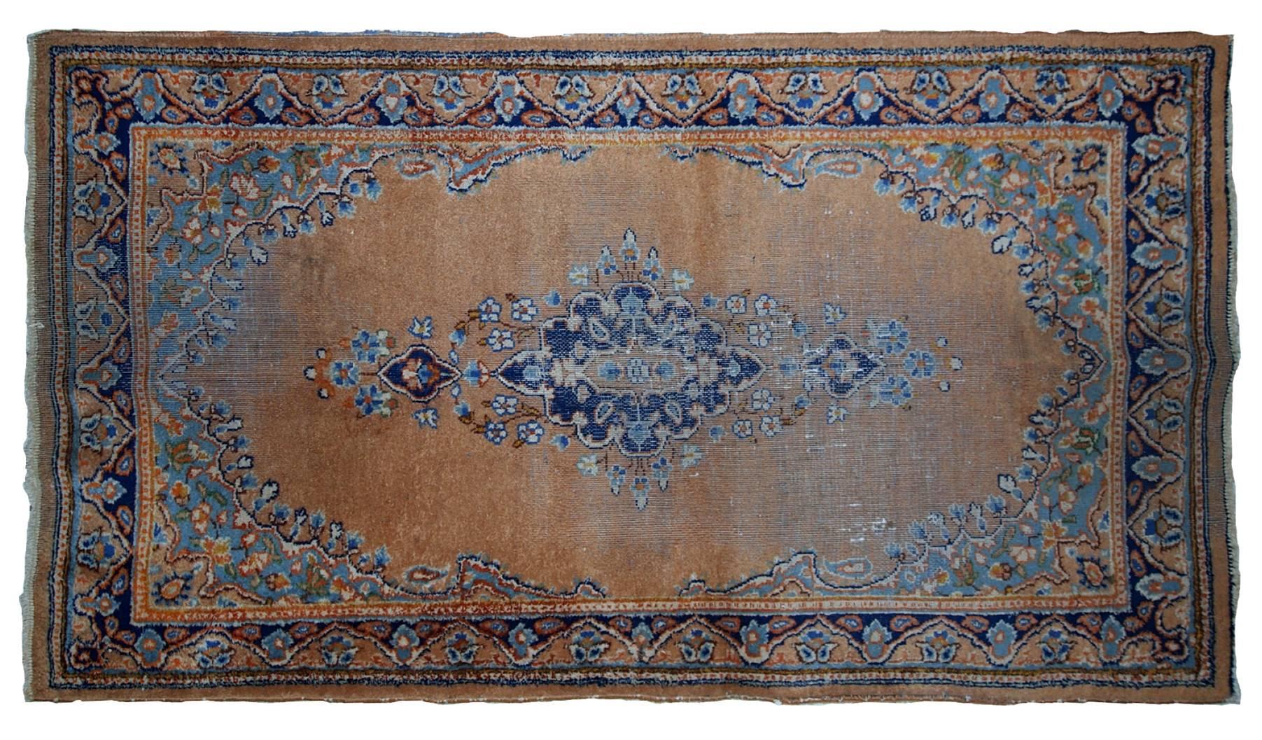 Handmade vintage Pakistani Lahore distressed rug in original condition. Brownish yellow background with sky blue details. The rug has low pile.
 