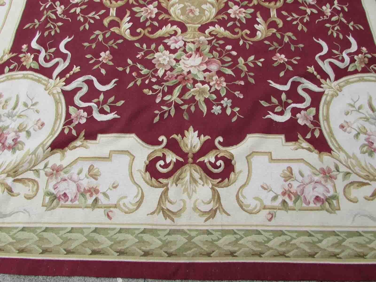 Handmade vintage French Aubusson rug in traditional floral design in burgundy and beige shades. This rug has been made in the end of 20th century and in original good condition.

-condition: Original good,

-circa: 1970s,

-Size: 9' x 11.9'