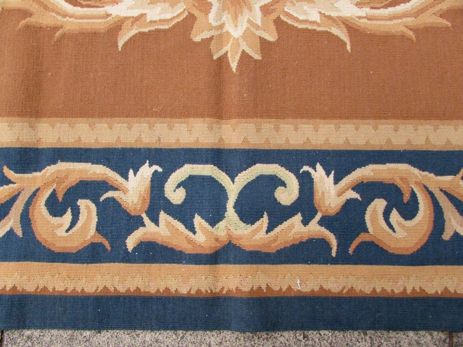 Handmade vintage French Aubusson rug in blue and brown wool. This rug has been made in the end of 20th century in original good condition.

-Condition: Original good,

-circa 1980s,

-Size: 6.8' x 9.9' (209cm x 302cm),

-Material: