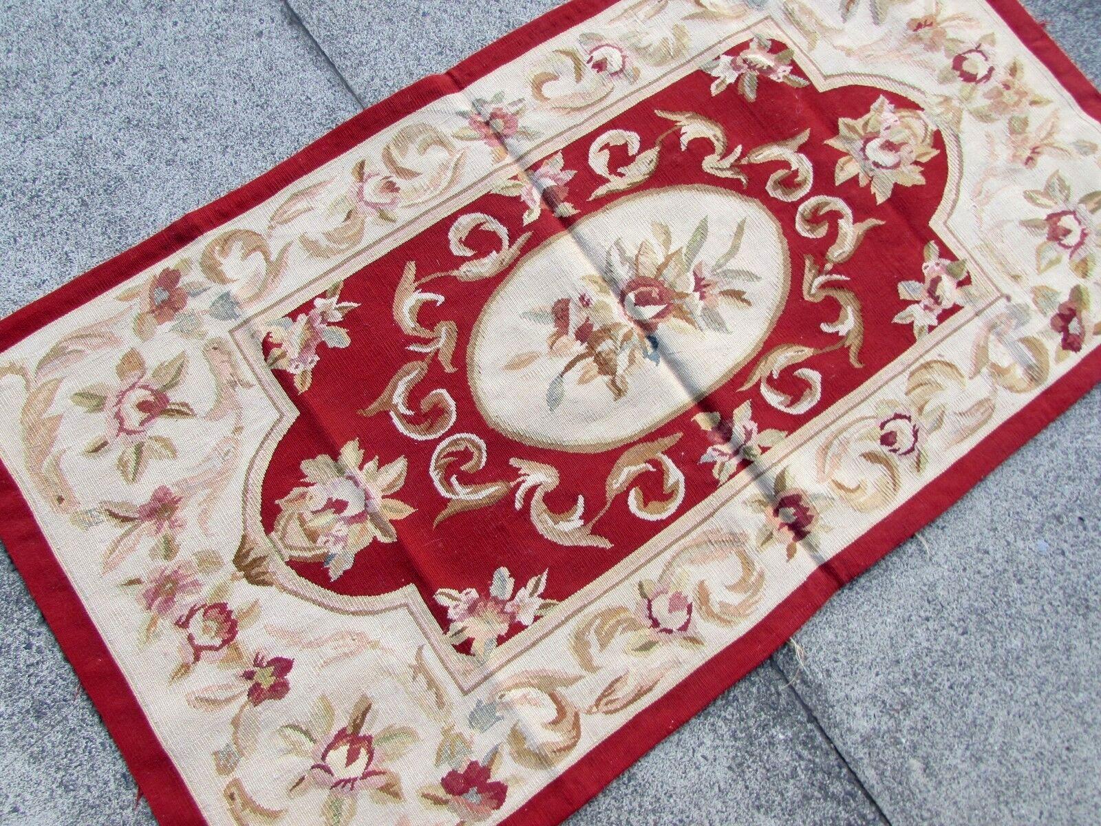 Add a touch of vintage elegance to your home decor with this exquisite handmade French Aubusson wool rug. Crafted in the Aubusson style, this high-quality rug features intricate floral and geometric patterns in beige, burgundy, brown, and