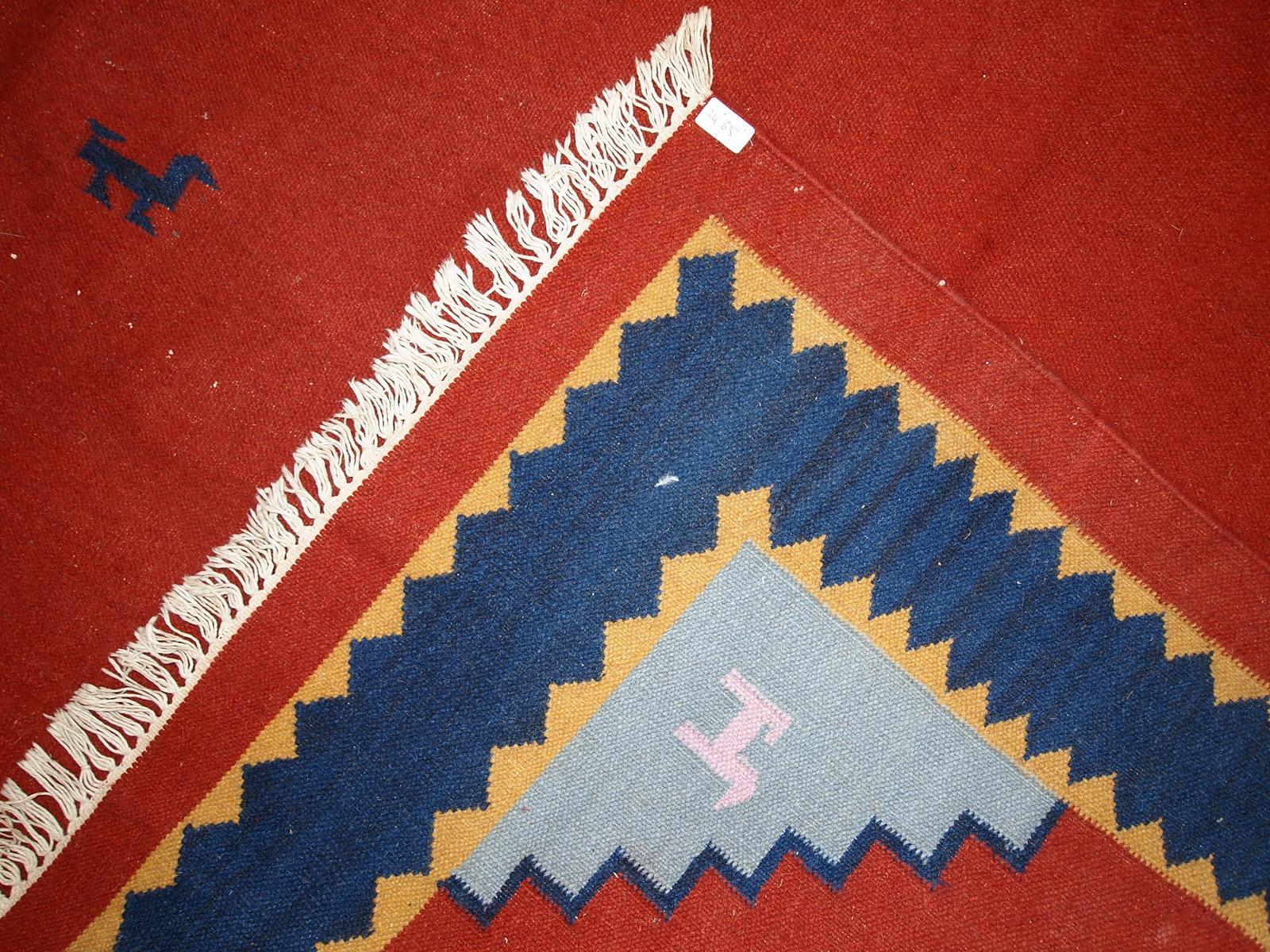 Mid-century kilim in red shade and all-over design. Miniature animals are in navy blue shade along with border. Sky blue colors are in each corner. The kilim is generally in original good condition, one corner is missing.

-condition: original,
