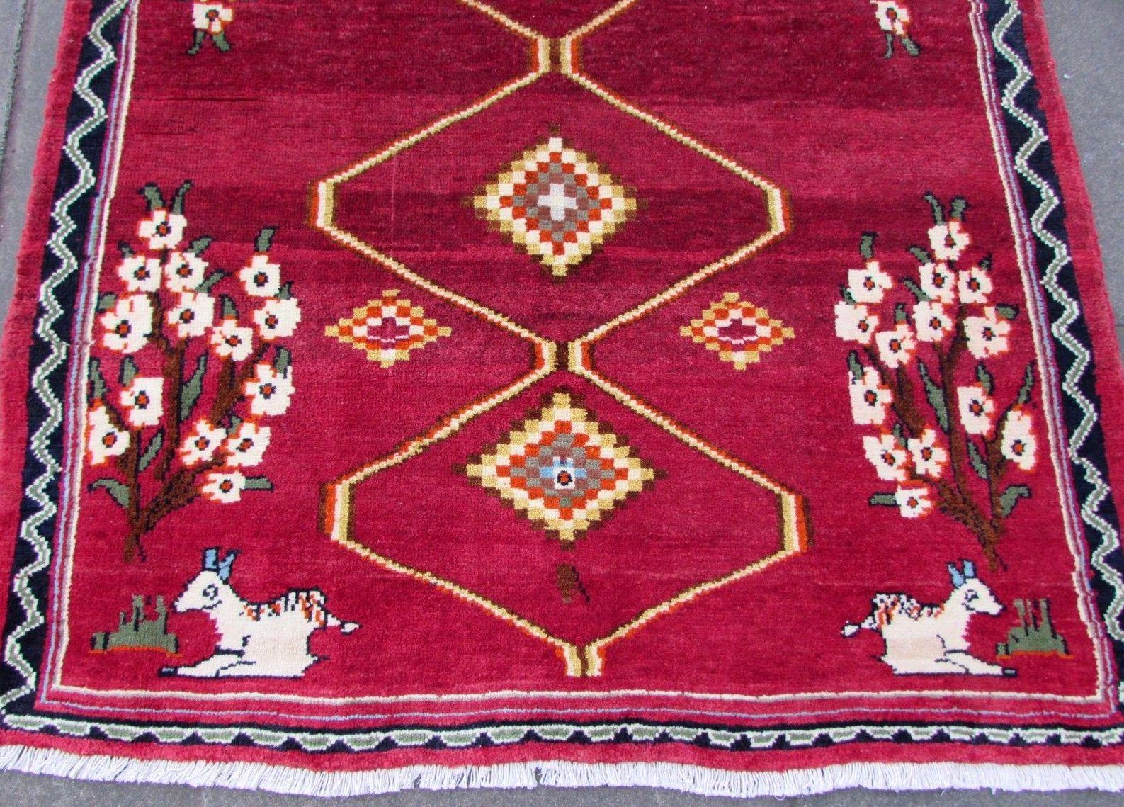 Handmade vintage Gabbeh style rug in bright red wool with animal scenes. The rug is from the end of 20th century in original good condition.

- Condition: original good,

- circa: 1980s,

- Size: 4.2' x 5.5' (126cm x 162cm),

- Material: