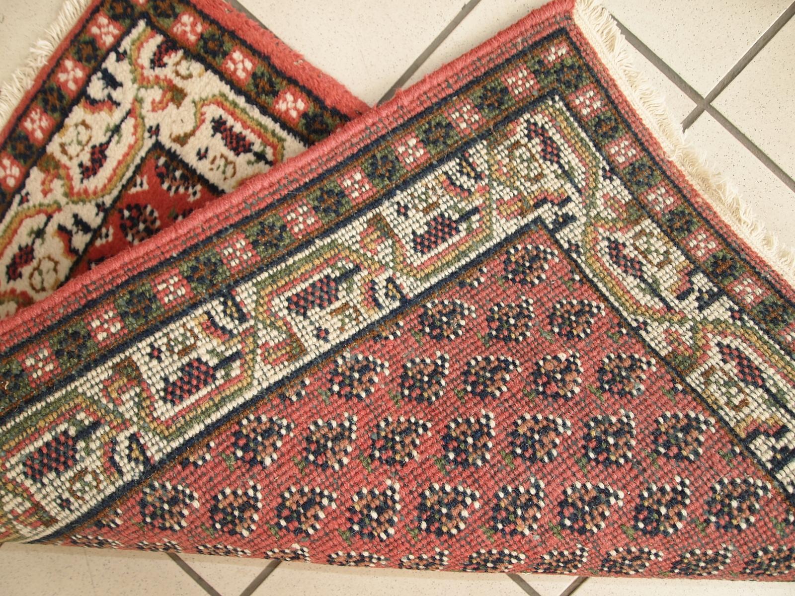 Pequeña alfombra vintage hecha a mano en la India en color rojo. Está en buen estado original de finales del siglo XX.

- Estado: original bueno,

- circa 1970s,

- Tamaño: 2' x 2,9' (62 cm x 90 cm),

- Material: lana,

- País de origen:
