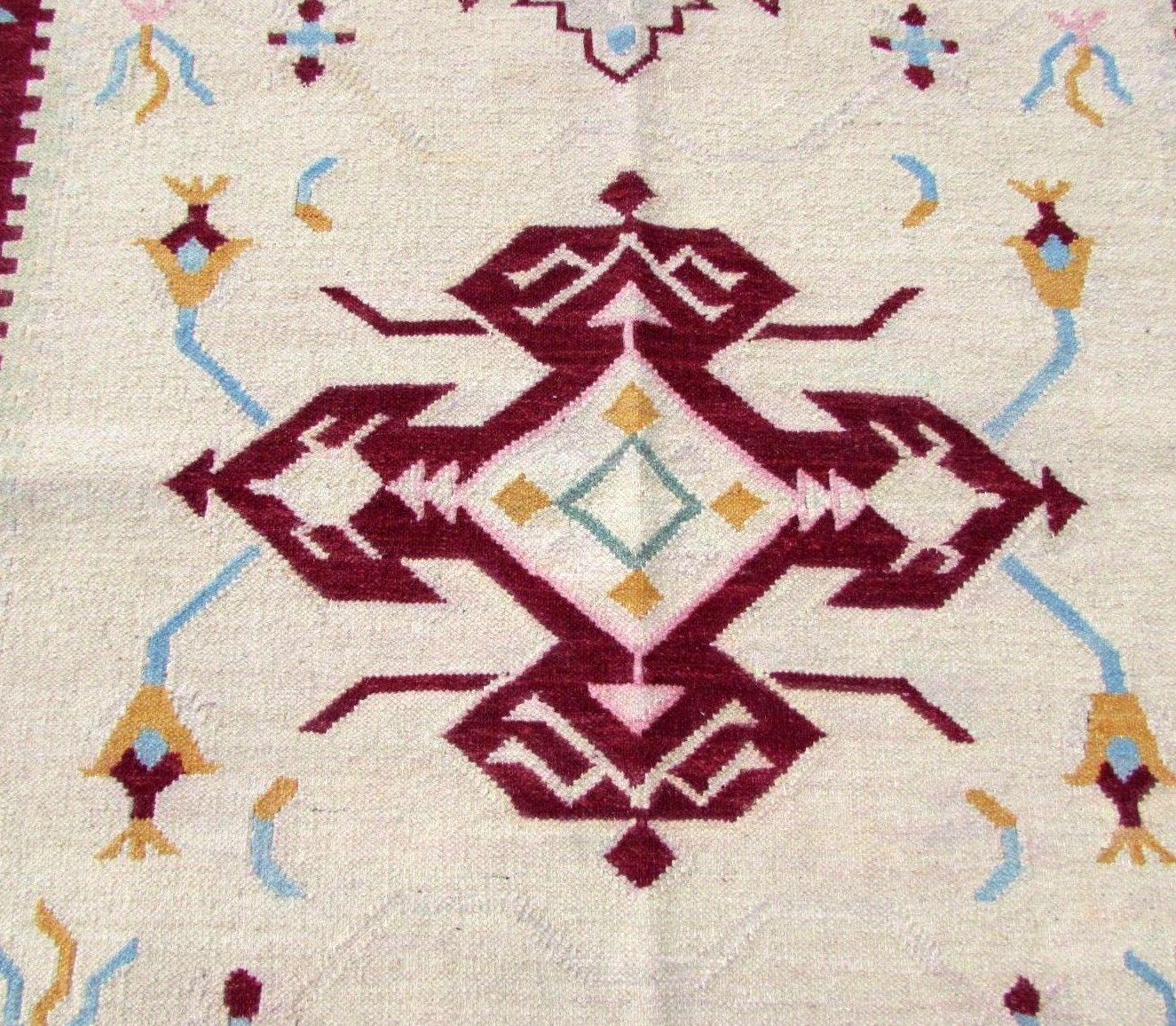 Handmade vintage Indian Dhurri kilim in beige and burgundy colors. It has been made in the end of 20th century in cotton.

-Condition: Original good,

-circa 1970s,

-Size: 5.5' x 7.6' (162cm x 224cm),

-Material: cotton,

-Country of
