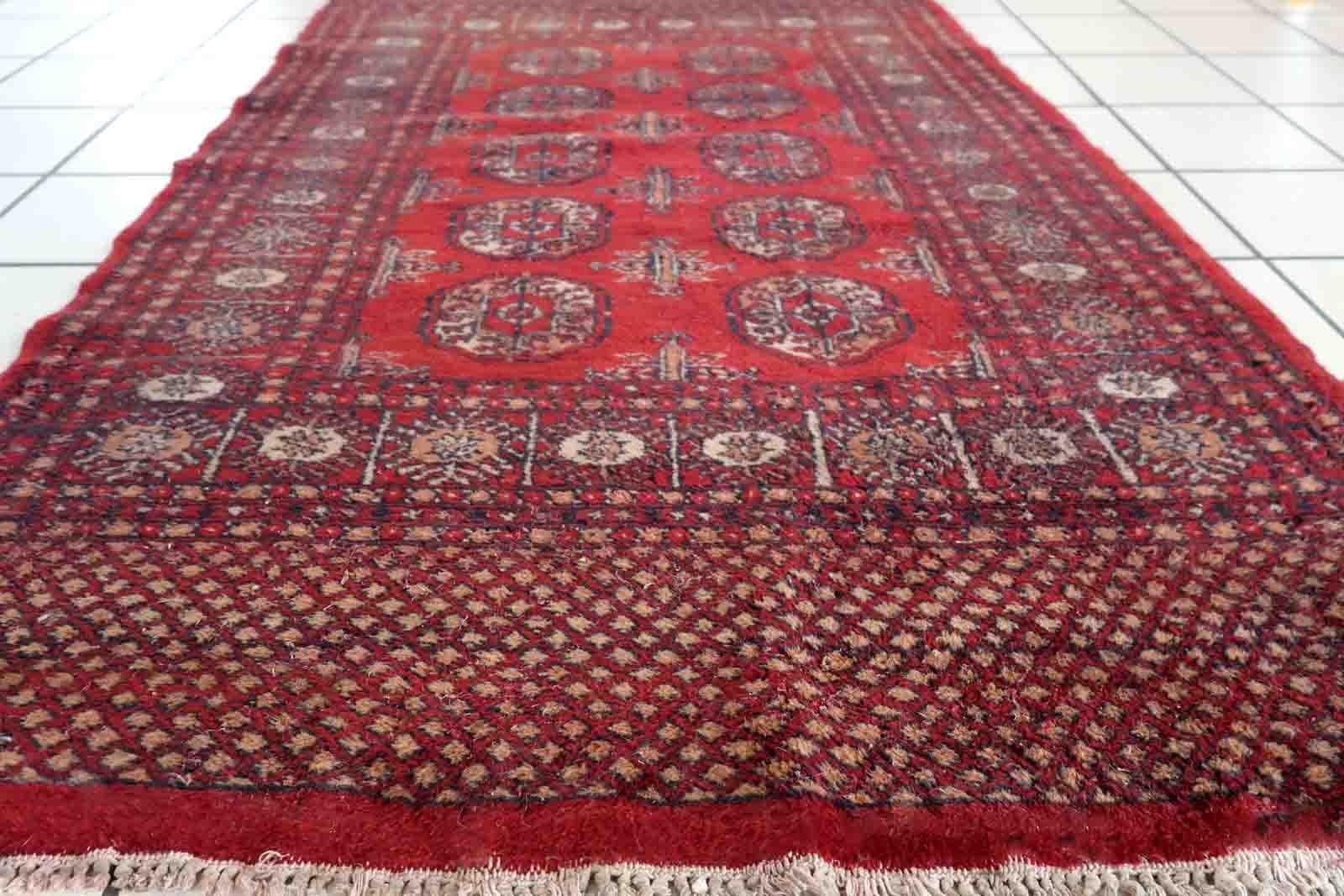 Handmade vintage Uzbek Bukhara rug in bright red color. The rug is from the end of 20th century in good condition, it has some signs of age and old restorations.

-condition: good, some signs of age and old restorations,

-circa:
